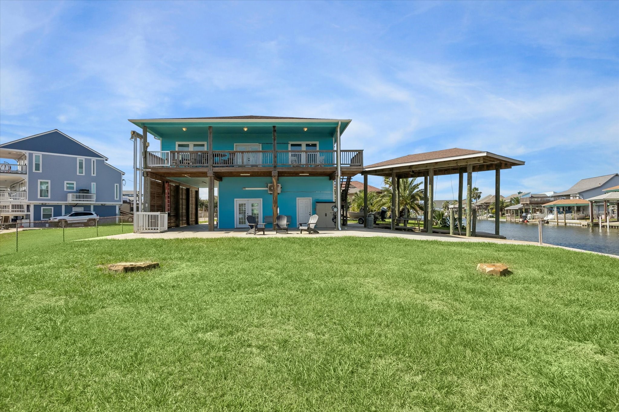 Charming waterfront home with a vibrant exterior, spacious covered porch, and direct canal access, perfect for enjoying serene water views.
