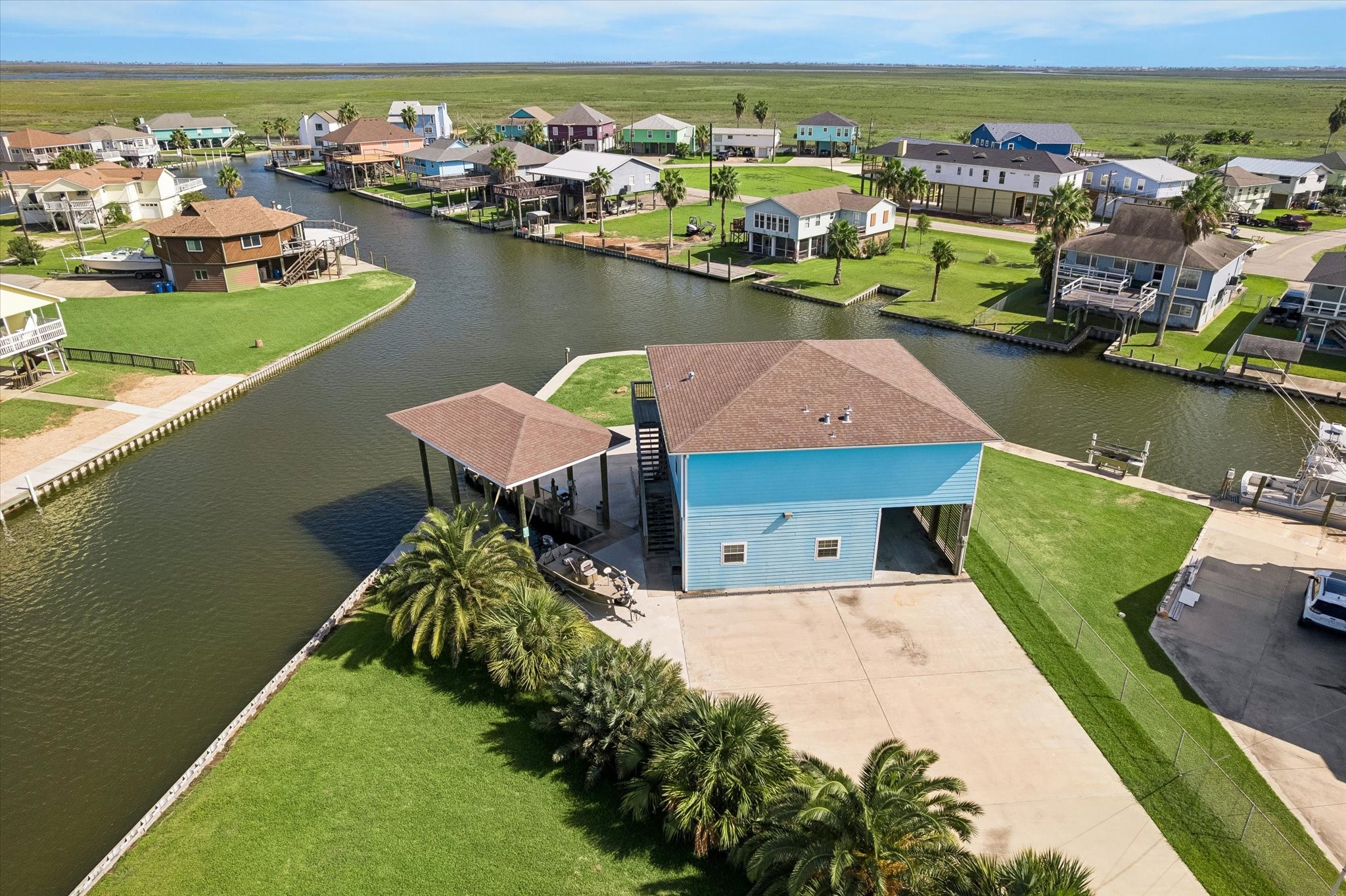 Waterfront property with a spacious boat dock, surrounded by lush greenery and offering direct canal access. Ideal for boating enthusiasts.