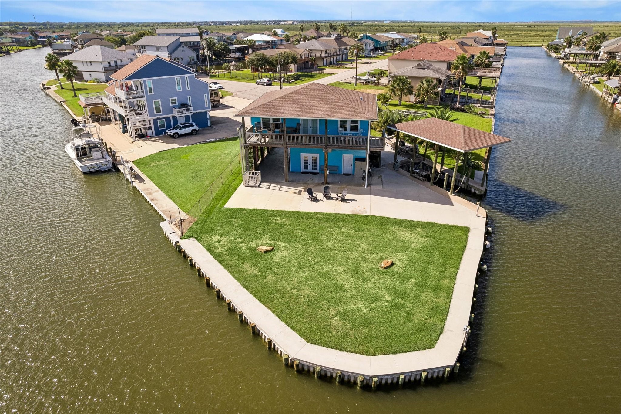 Charming waterfront home on a spacious canal-front lot, featuring a large deck, boat dock, and lush green lawn perfect for outdoor enjoyment.Located on a corner lot with 180 degree view.