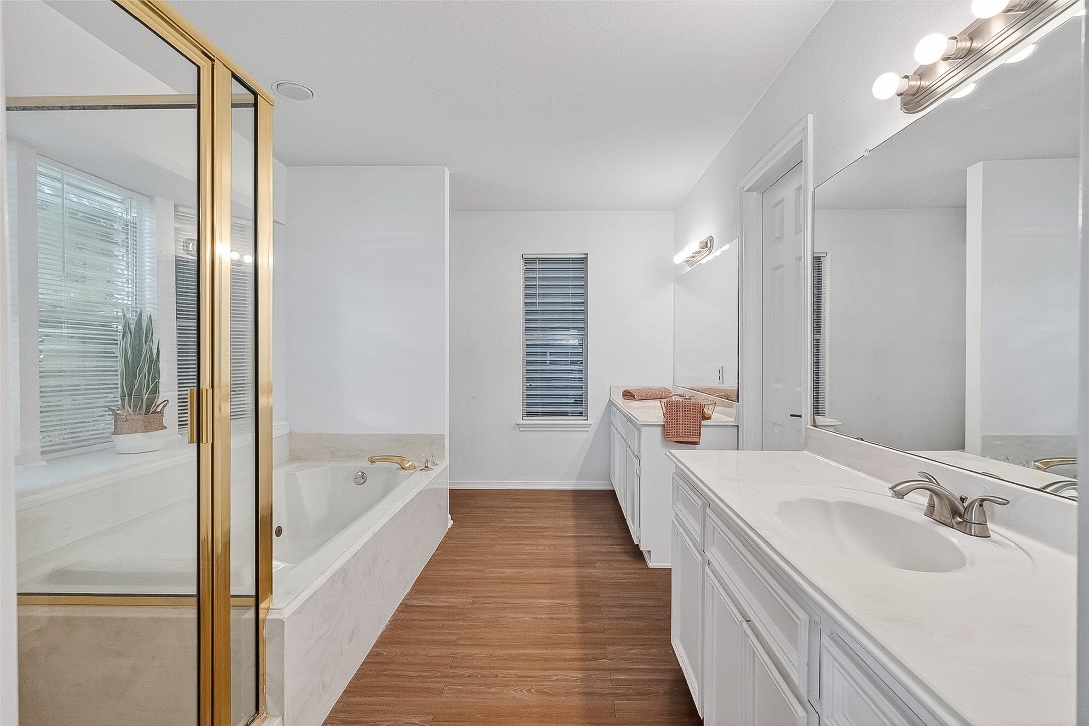 Primary bathroom's ensuite bathroom with walk in closet on the right between his and hers vanitys, full sized jetted tub and seperate shower! Primary bathroom's ensuite bathroom with walk in closet on the right between his and hers vanitys, full sized jetted tub and seperate shower!