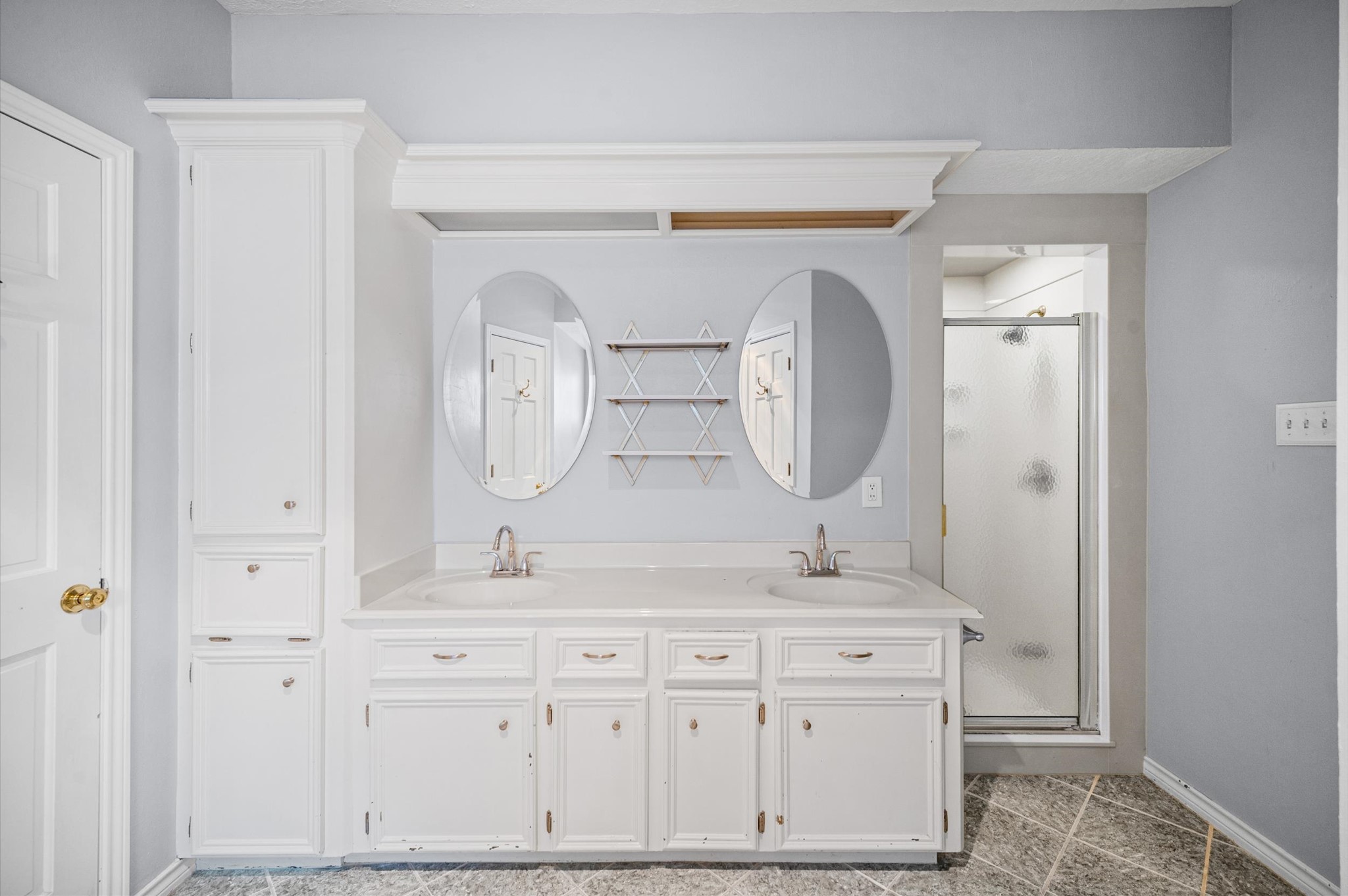 A light and bright primary bath features dual sinks, an oversized tub with separate shower, and two walk-in closets.