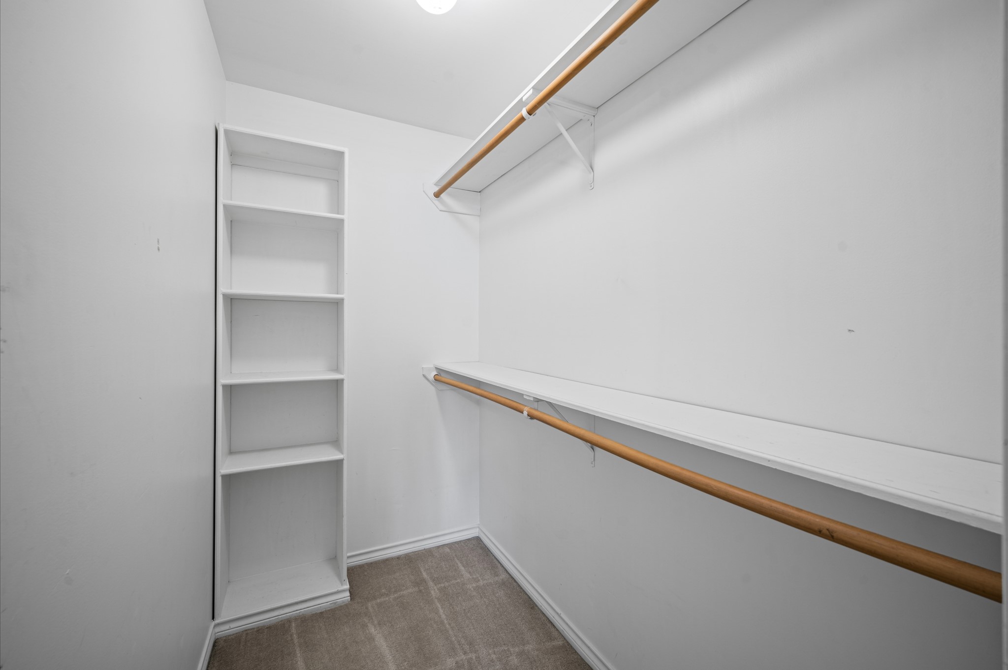 Look at the size of this walk-in closet with built in shoe shelves for this secondary bedroom.