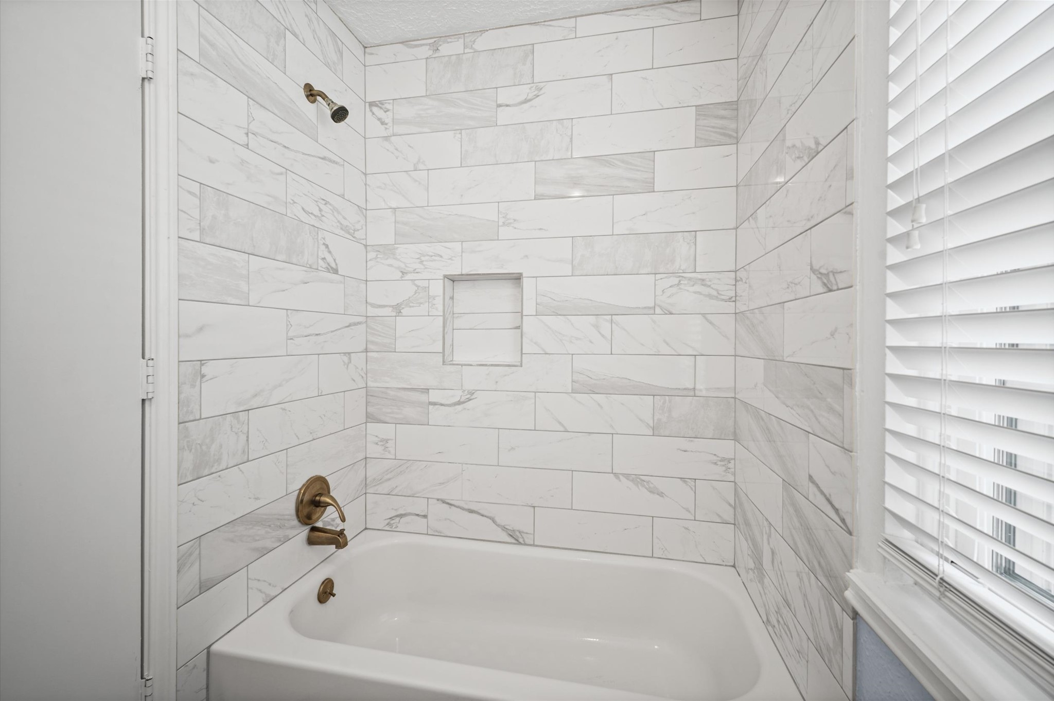 Modern tile adorn this tub/shower combo in the secondary bathroom upstairs.