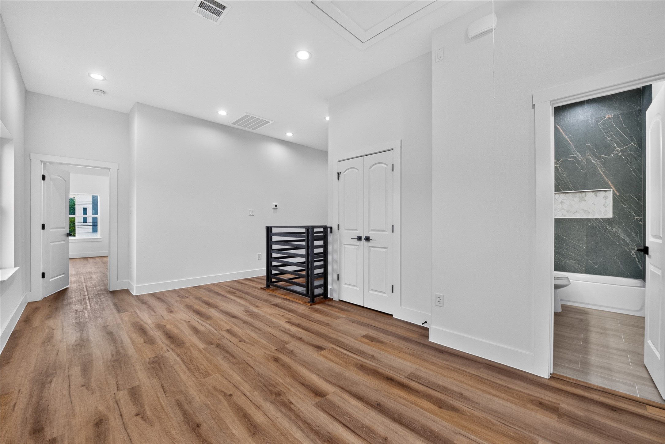 The stairs lead to a bright, expansive flex space designed to adapt beautifullyideal for a home office, media room, gym, or additional living area. To the right, a convenient utility closet and full secondary bath add thoughtful function and flexibility to the upper level. Washing machine and dryer provided.