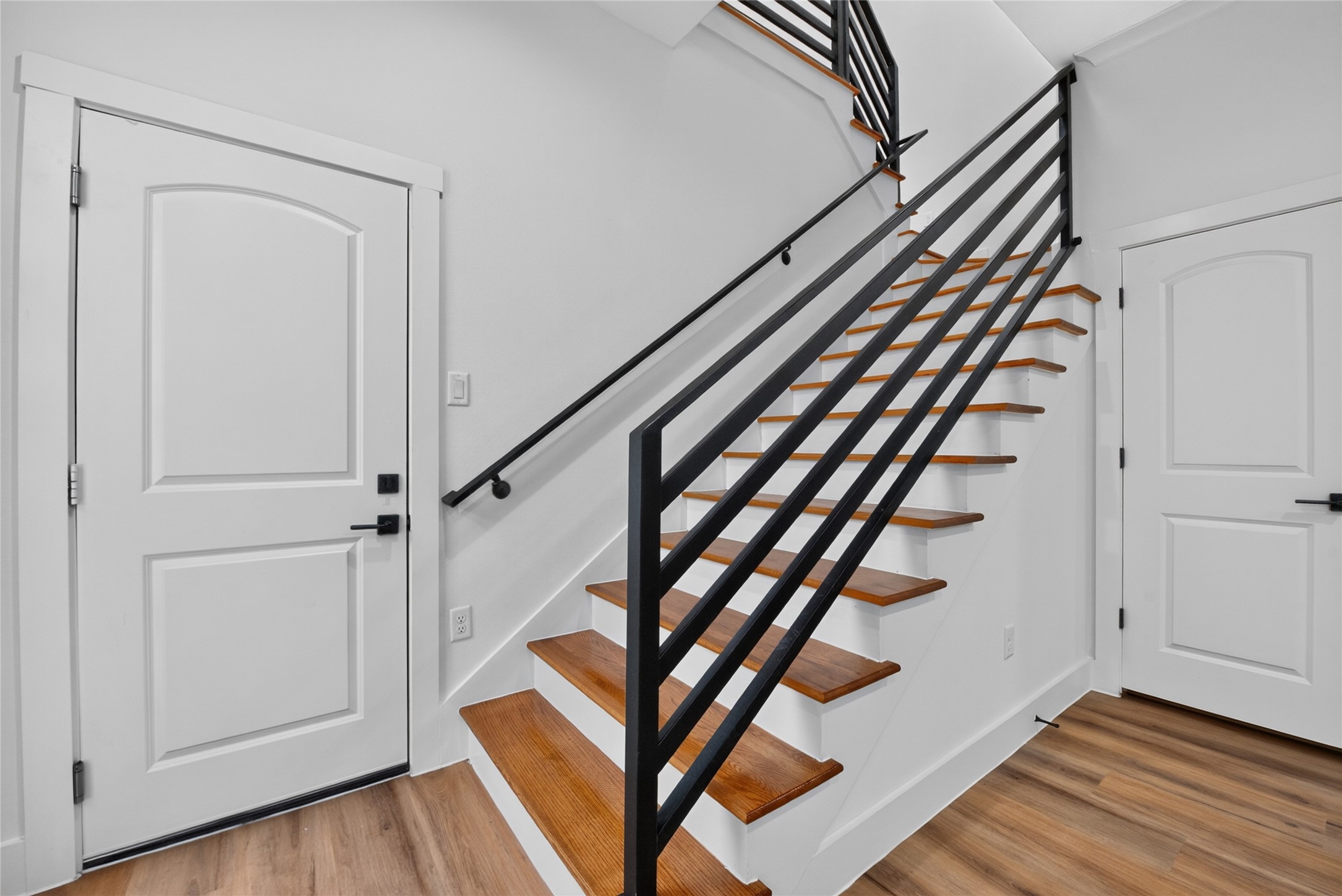 A convenient garage entry opens directly into the living spaces, while steps to the side lead upstairs to the flex space, bedrooms, and baths.