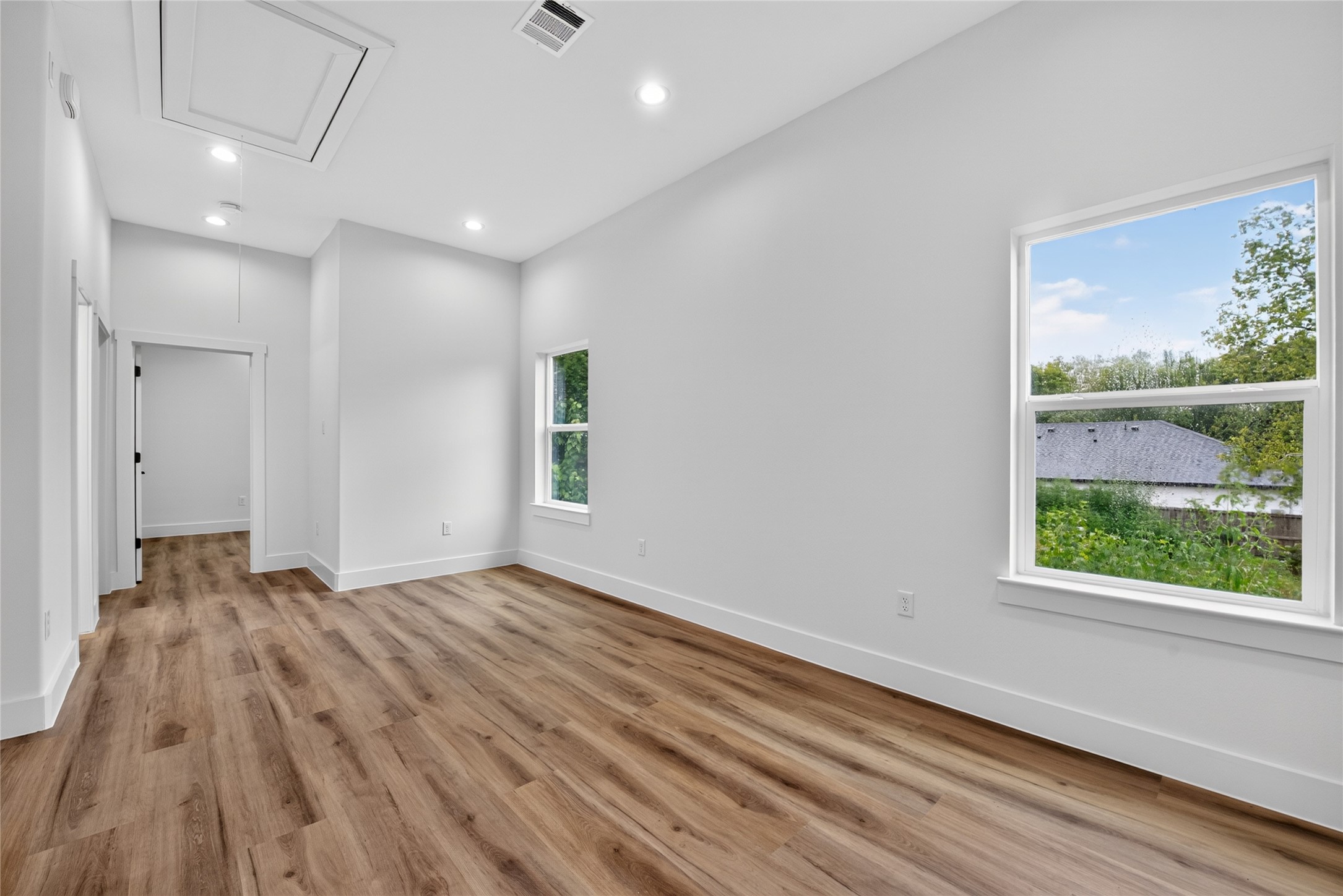 Another view of the generous flex space, featuring windows that fill the room with natural light and give you the flexibility to create a space that fits your lifestyle. Two well-sized secondary bedrooms are privately positioned on the far side of the upper level, complemented by a full bath for added comfort and convenience.