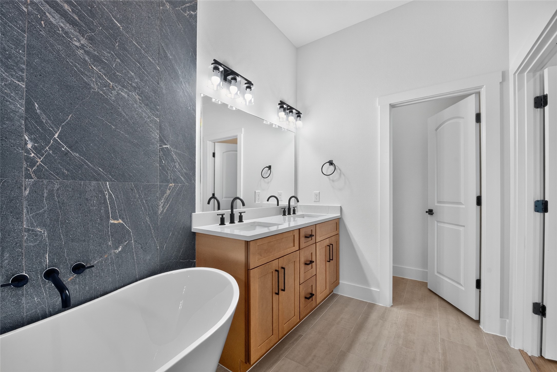 A beautifully finished primary bath centered around a deep soaking tub and dual vanities offers a sophisticated space to begin and end the day.