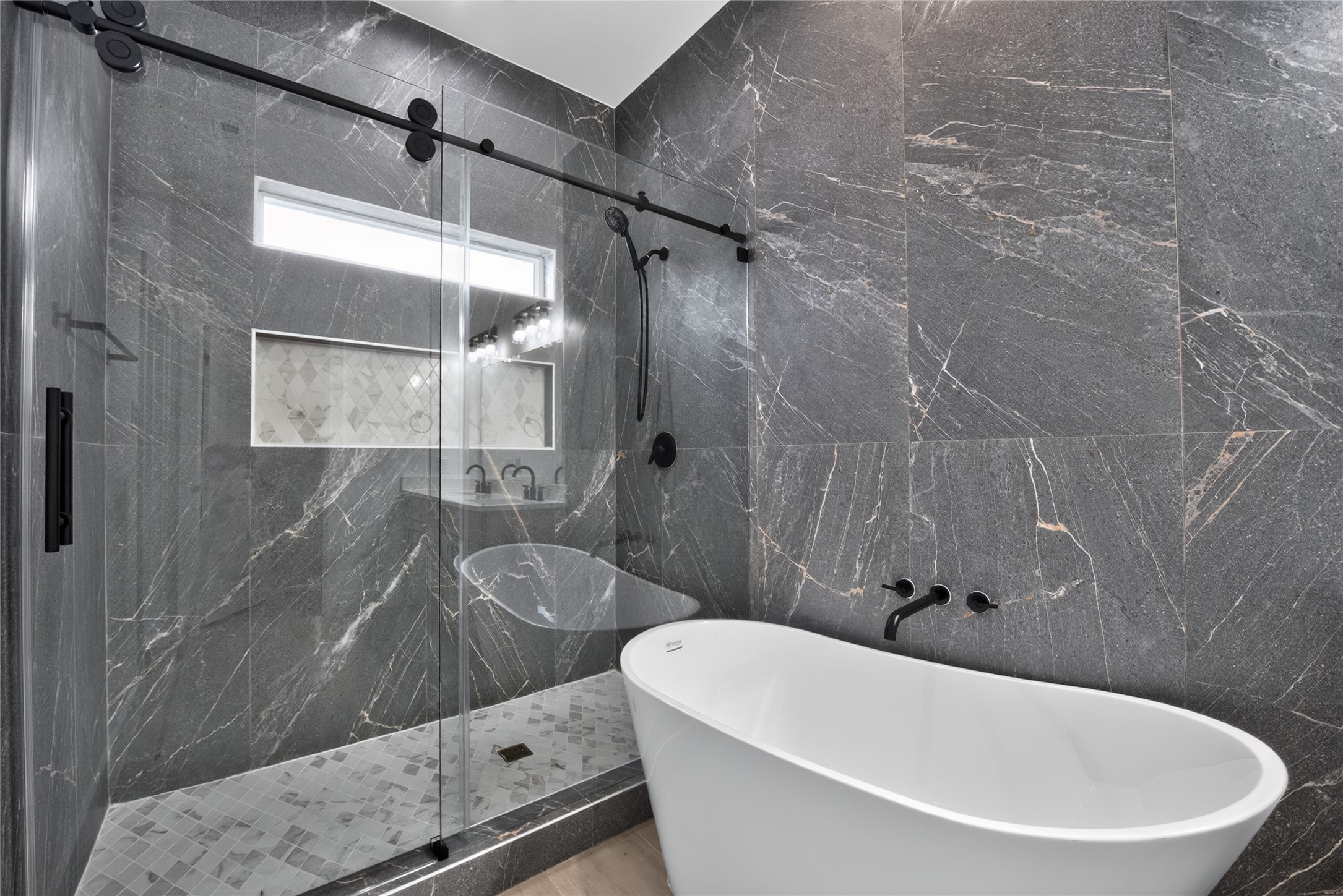 Oversized and beautifully finished, the shower features sliding glass doors and floor-to-ceiling tile for a sleek, sophisticated look.