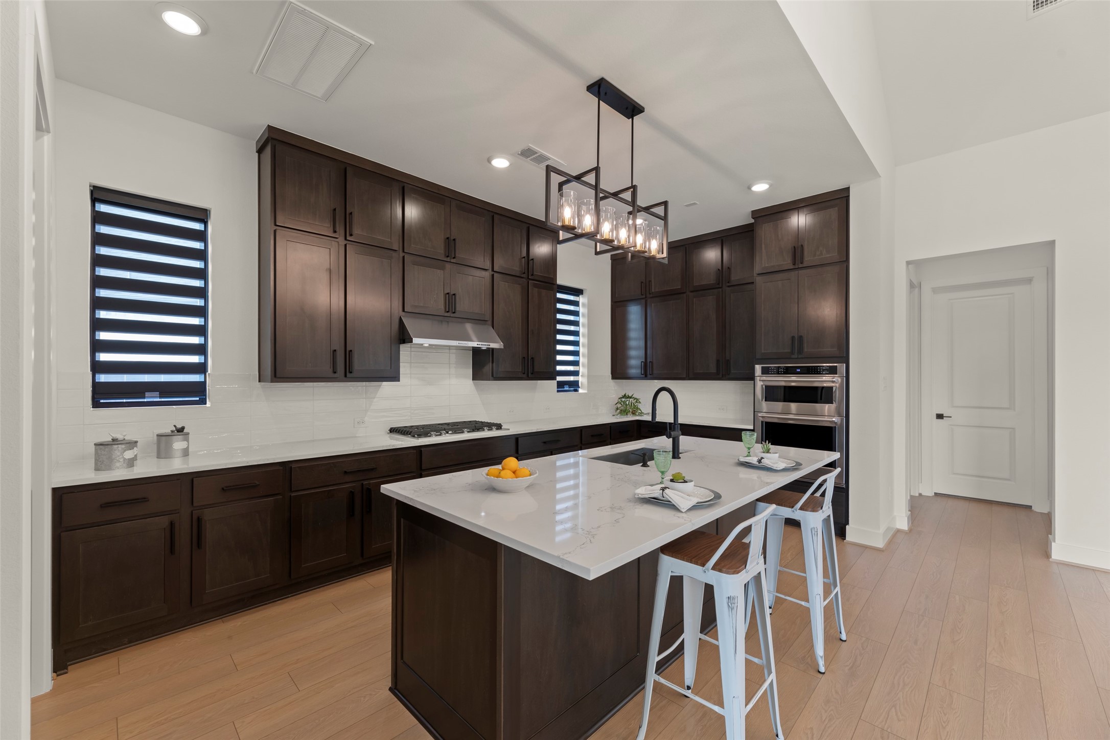 Large island with seating, and modern pendant lighting.