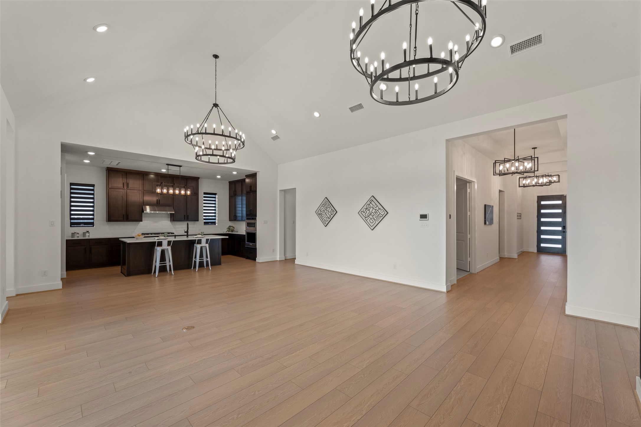 Spacious open-concept family room area featuring elegant chandeliers.