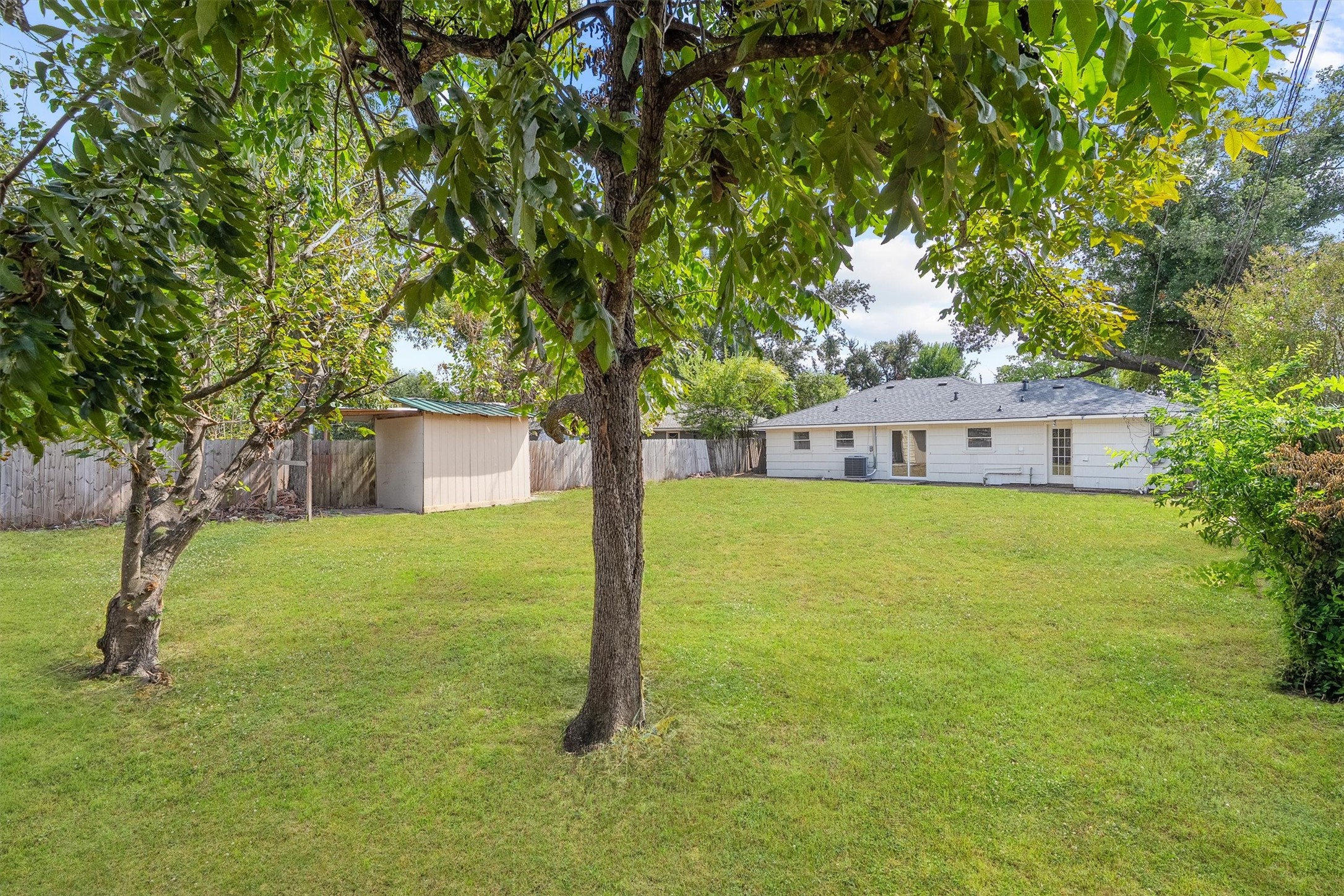 Expansive backyard with lush greenery, mature trees, and a convenient storage shed, perfect for outdoor activities and relaxation. Expansive backyard with lush greenery, mature trees, and a convenient storage shed, perfect for outdoor activities and relaxation.