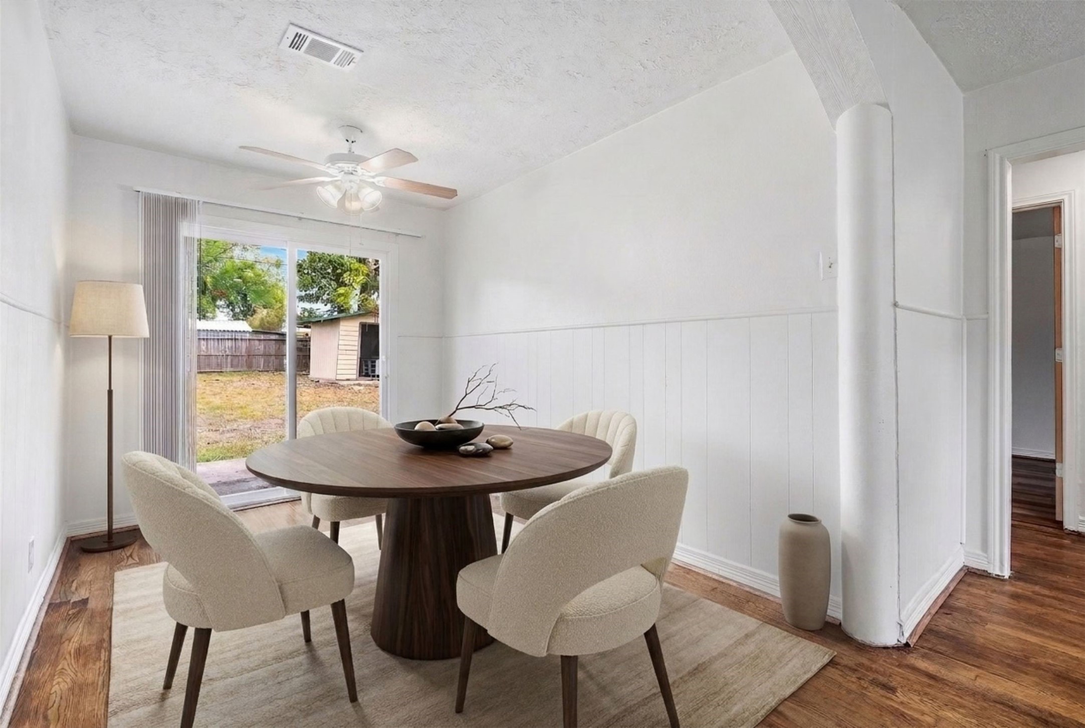 Experience the perfect blend of style and comfort in this dining area, featuring a serene view of the backyard through sliding glass doors. (Virtual Staging)