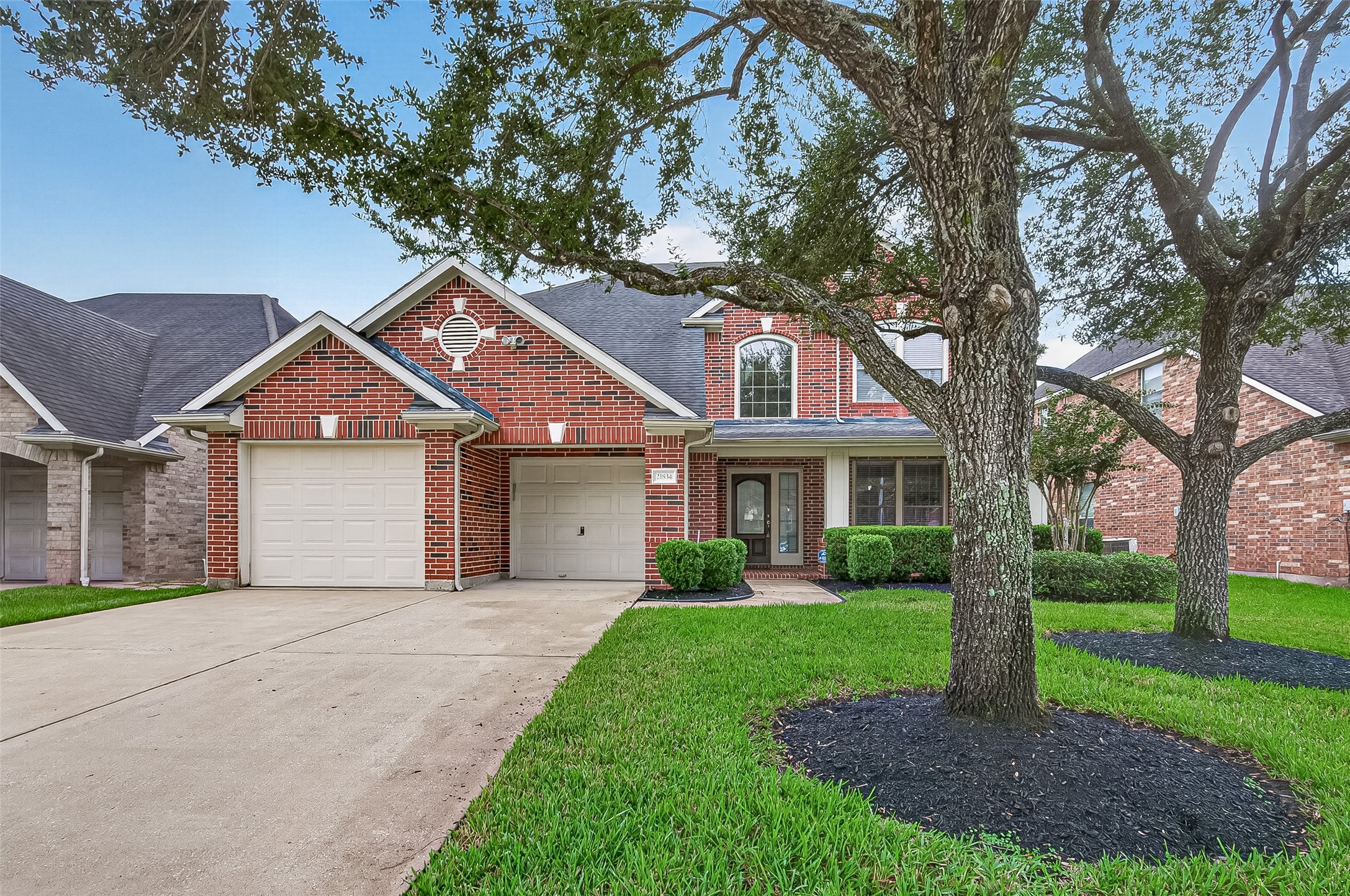 This home features a classic brick exterior with a spacious double-wide driveway leading to a 3-car tandem garage, offering plenty of room for vehicles and storage. The inviting entry and well-designed front elevation create a polished, welcoming first impression.
