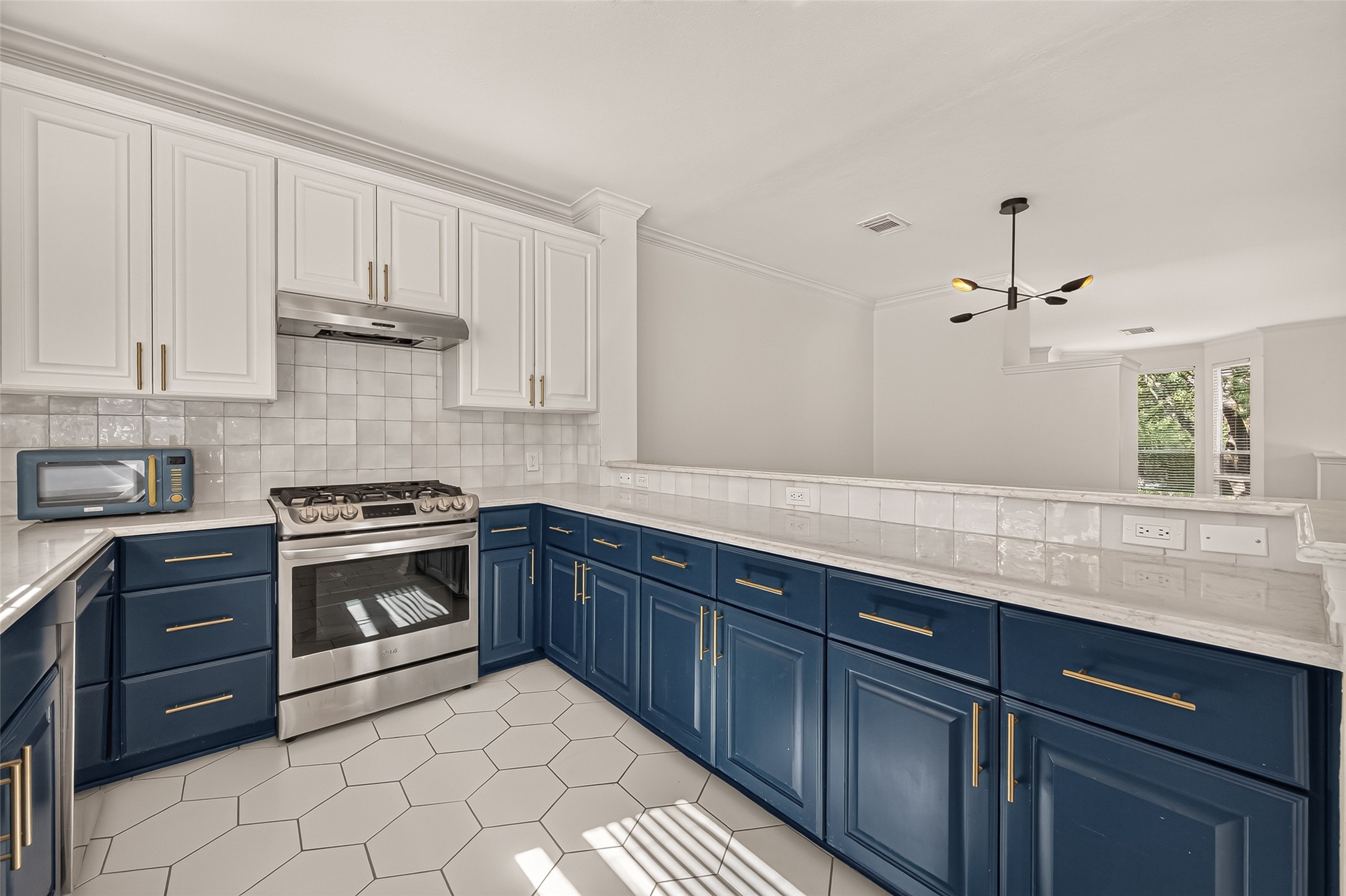 Beautifully updated kitchen with a modern, thoughtfully designed layout, plenty of counter space, ample cabinetry, and a sunny window over the sink.