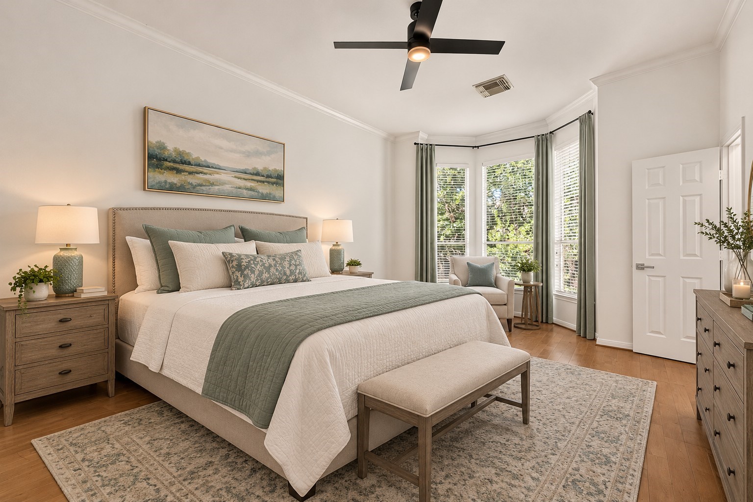 The large primary bedroom features beautiful bay windows that fill the room with natural light, complemented by warm wood flooring for a bright, comfortable retreat.