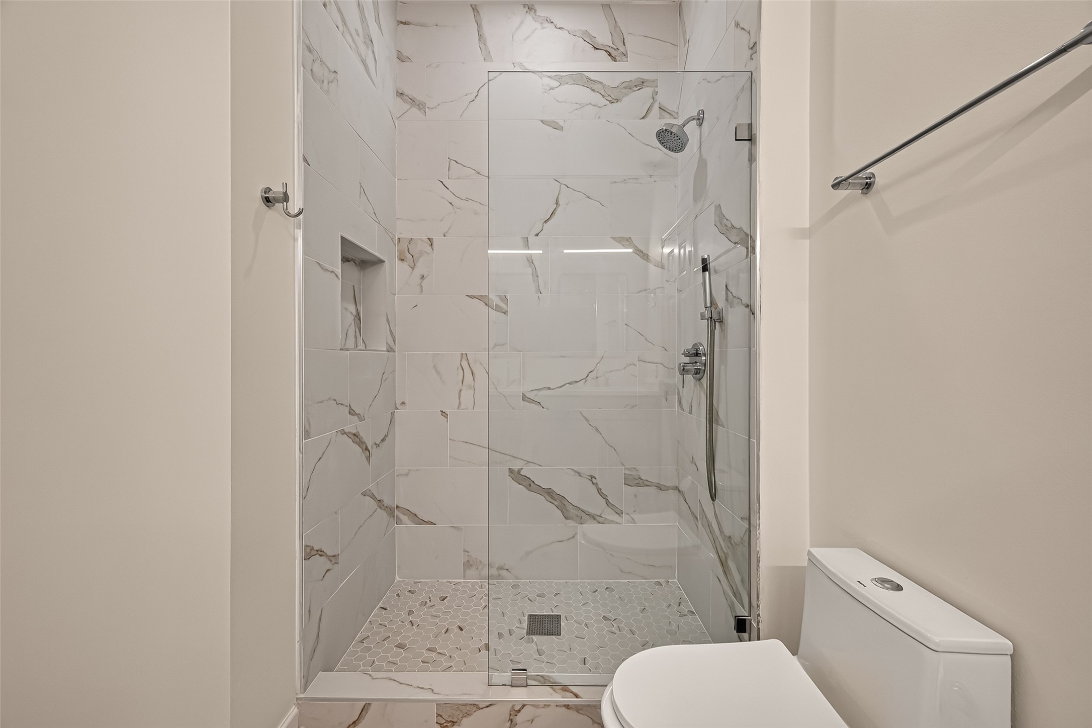 Beautifully designed walk-in shower featuring dual showerheads for a refreshing, spa-like experience.