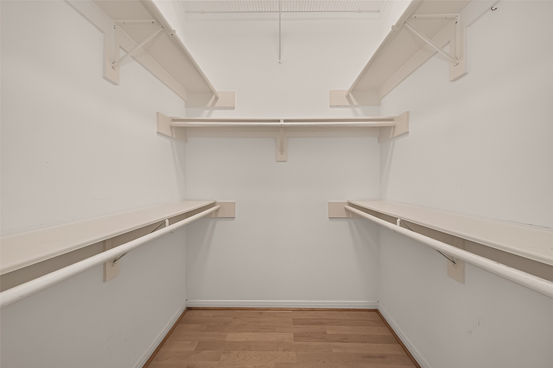 The primary bedroom features two walk-in closets, offering plenty of room for clothing, shoes, and accessories.