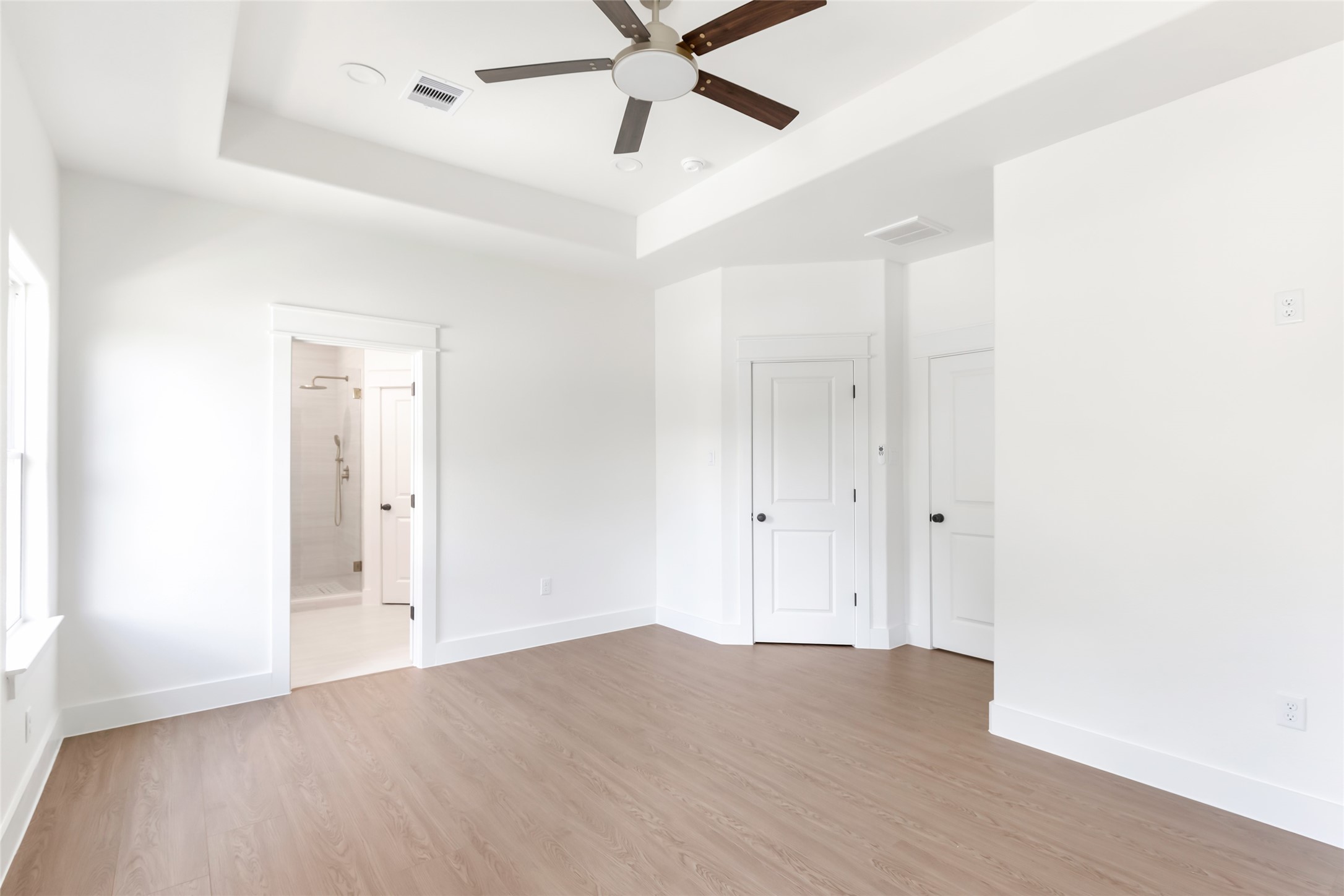 Primary ensuite with tray ceiling and attached bathroom. Primary ensuite with tray ceiling and attached bathroom.
