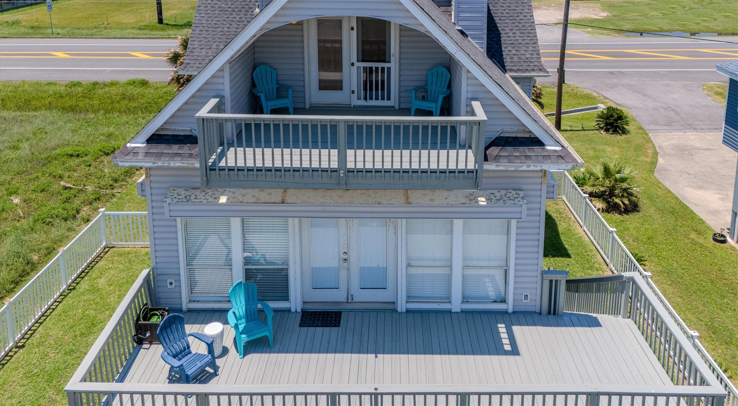 This charming home has spacious dual-level decks, perfect for outdoor relaxation. The upper balcony offers a cozy spot with seating, while the lower deck provides ample space for gatherings. It's set in a convenient location near the beach, with a partially fenced yard for added privacy.