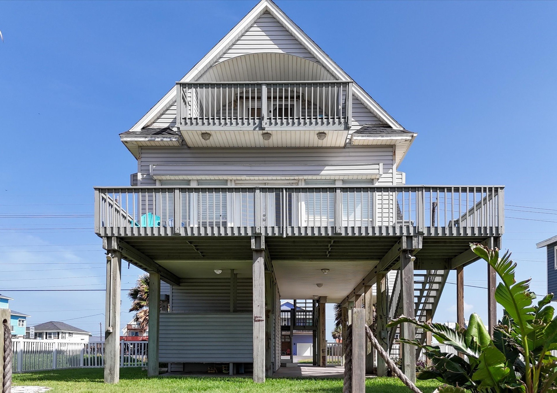 Elevated coastal home with two decks, providing ample outdoor space. The house features a stilt design, and is built high to deal with any potential flood but also to provide wonderful views. Perfect for enjoying seaside living.
