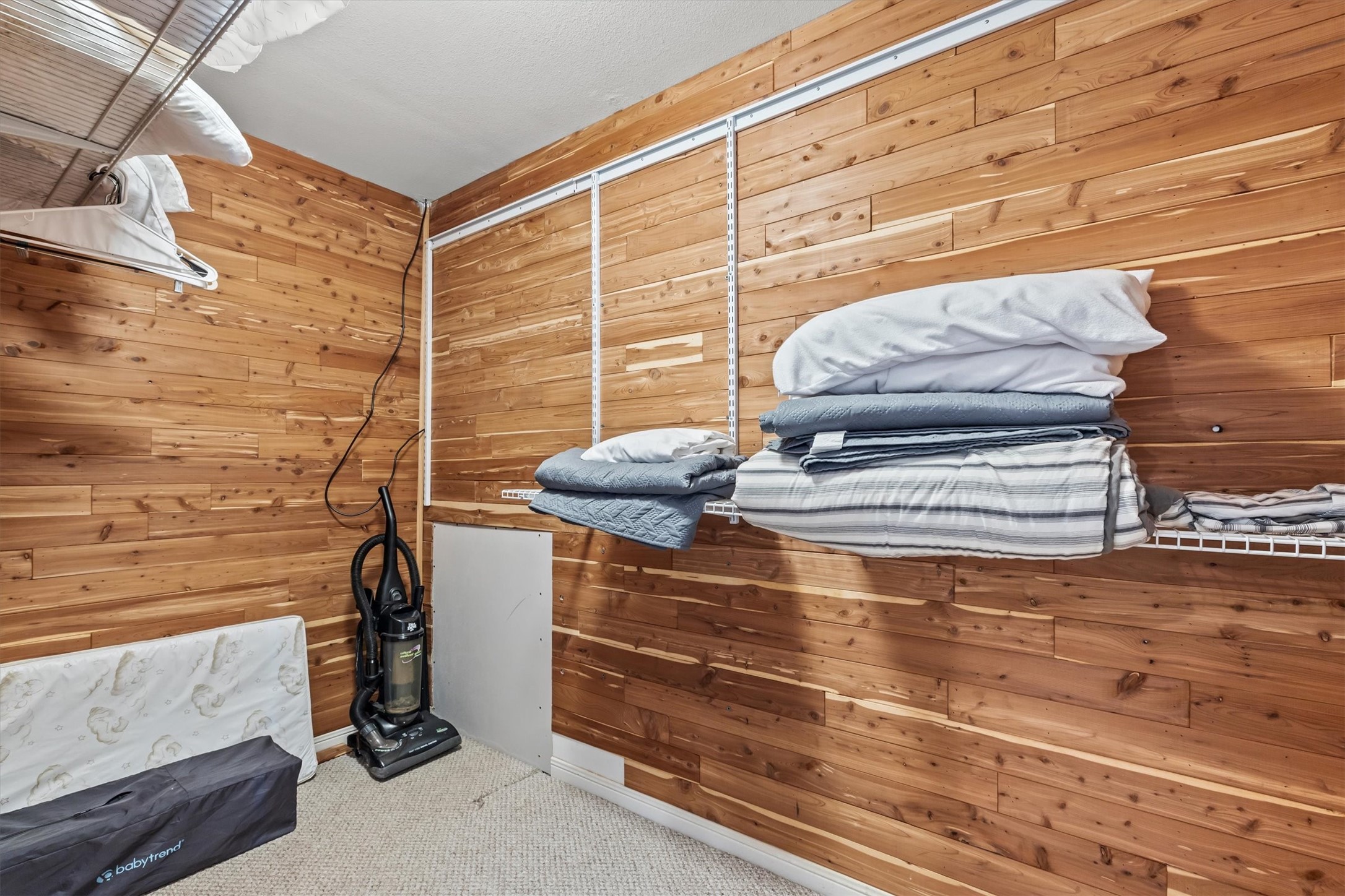 This home offers abundant storage solutions with a beautifully cedar paneled, large closet, featuring convenient shelving and a hanging rod perfect for organizing your essentials.
