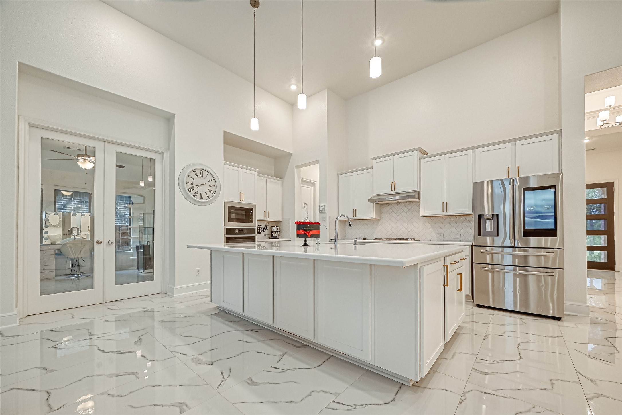A chefs dream kitchen featuring an oversized statement island and upgraded cabinetry adorned with elegant hardware and crown molding, delivering a luxurious blend of timeless craftsmanship and sophisticated design