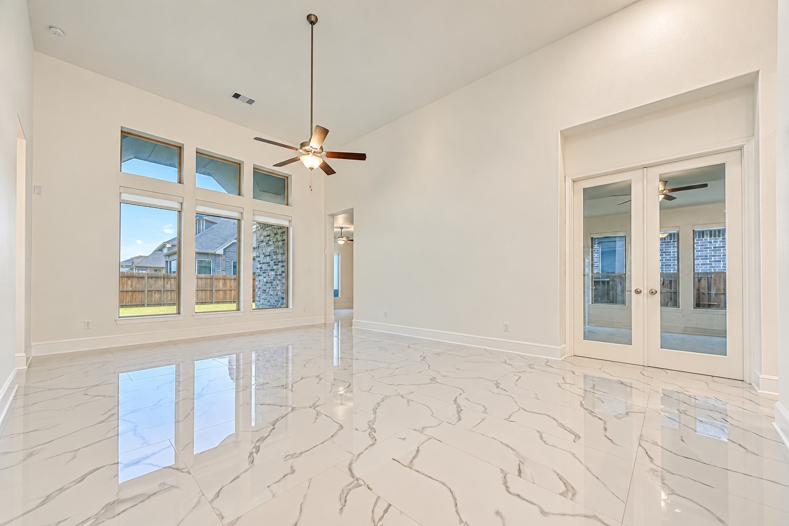 A bright, modern family room featuring a dramatic wall of windows that fills the space with abundant natural light, creating an inviting atmosphere for everyday living and elegant entertaining