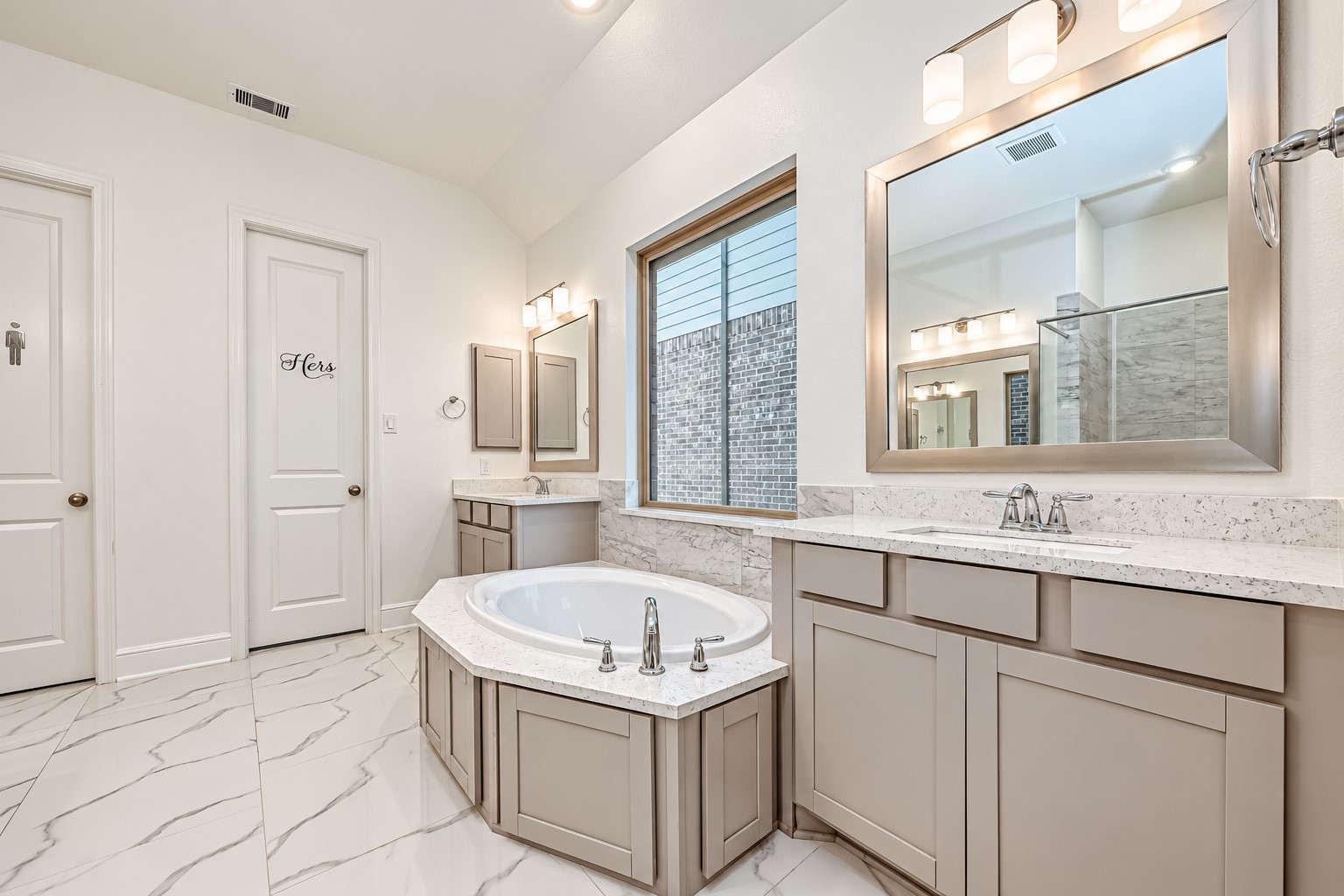 An modern primary bathroom designed for a spa-like experience, featuring elegant double vanities, a sleek glass-enclosed shower, and a luxurious soaking tub, creating a sophisticated sanctuary for relaxation and indulgence