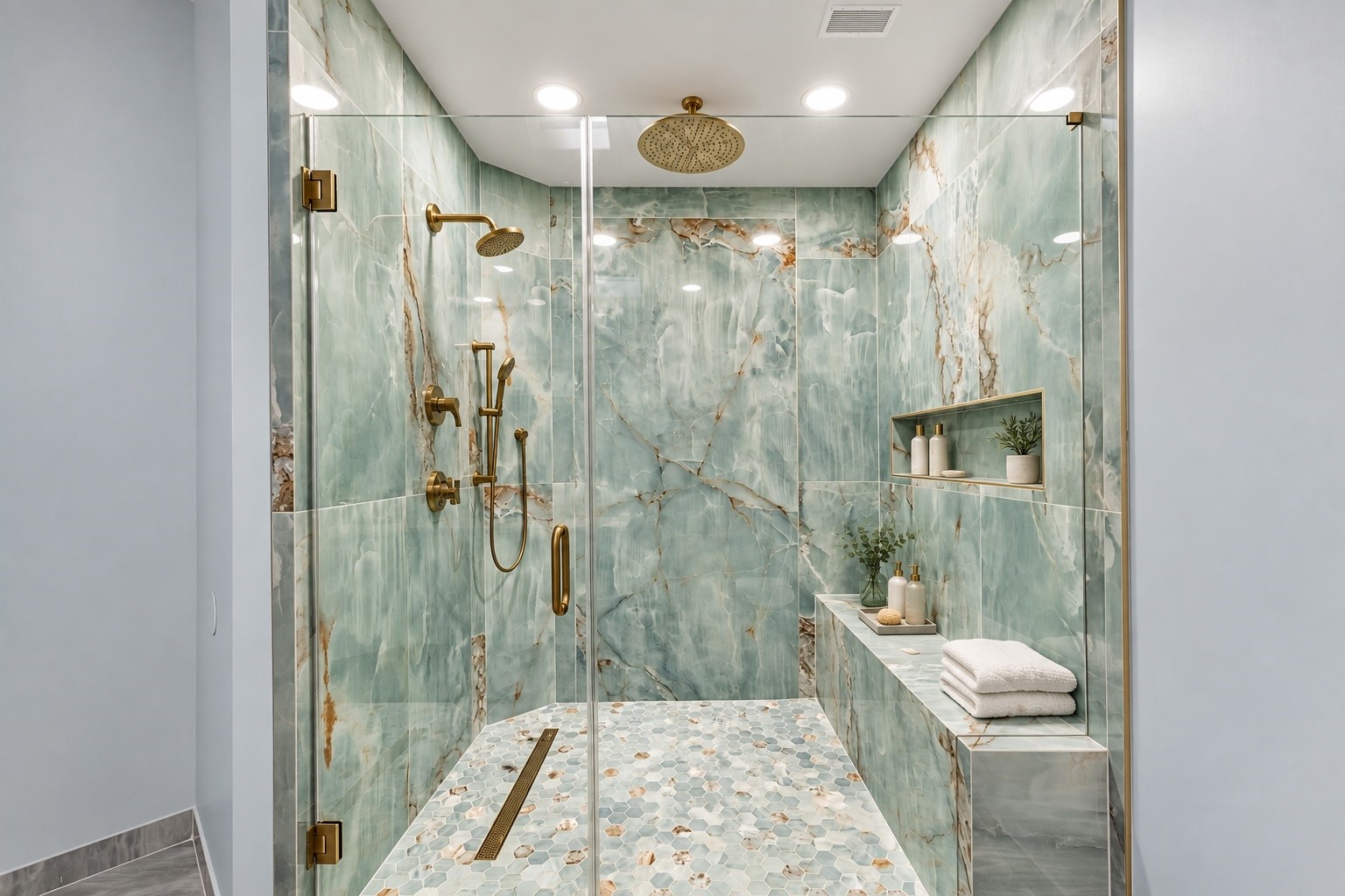 An elegant glass-enclosed shower showcases dramatic stone surfaces, beautiful tilework, polished fixtures, and a generously proportioned design.