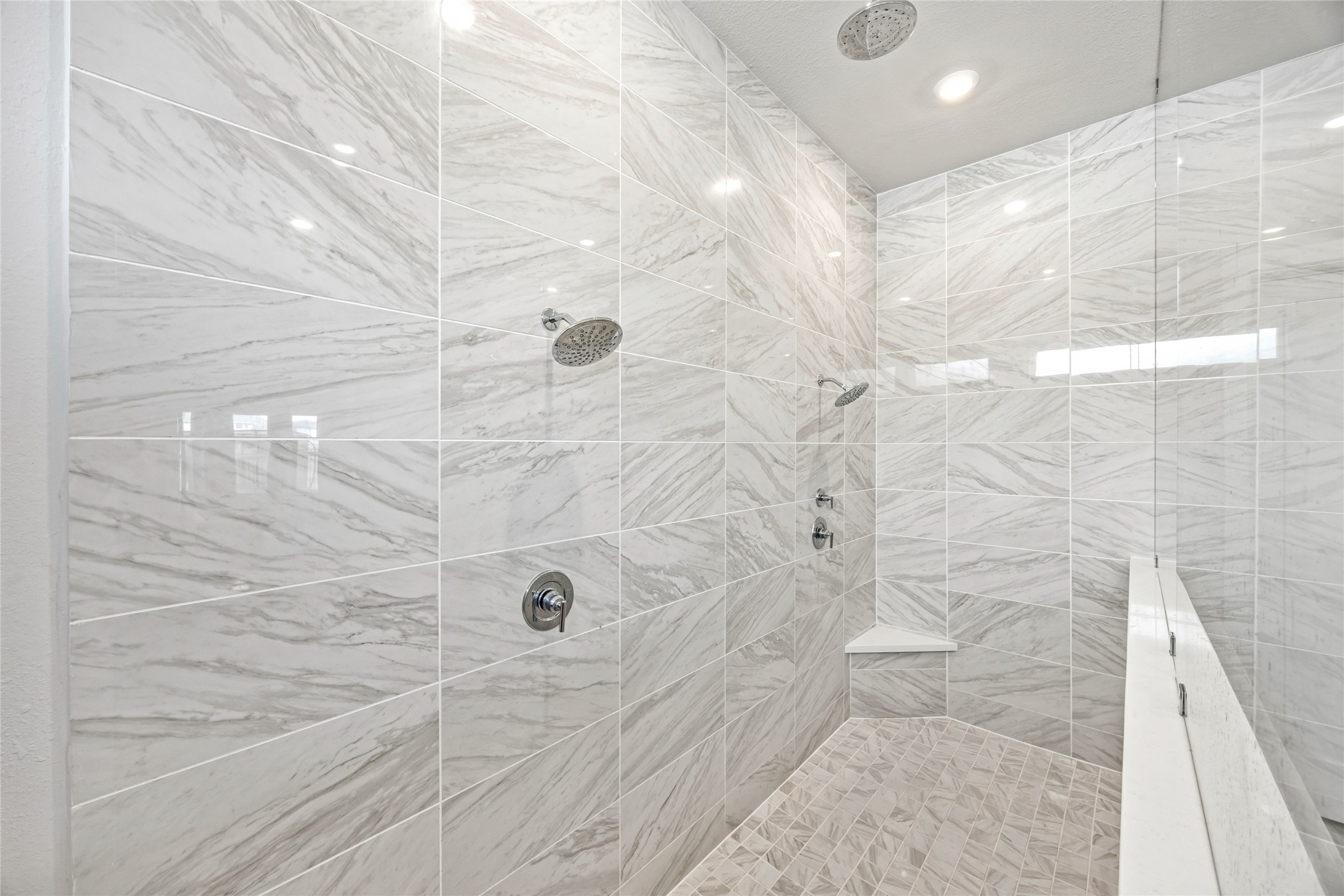 An elegant, oversized shower featuring three showerheads for ultimate comfort and luxury