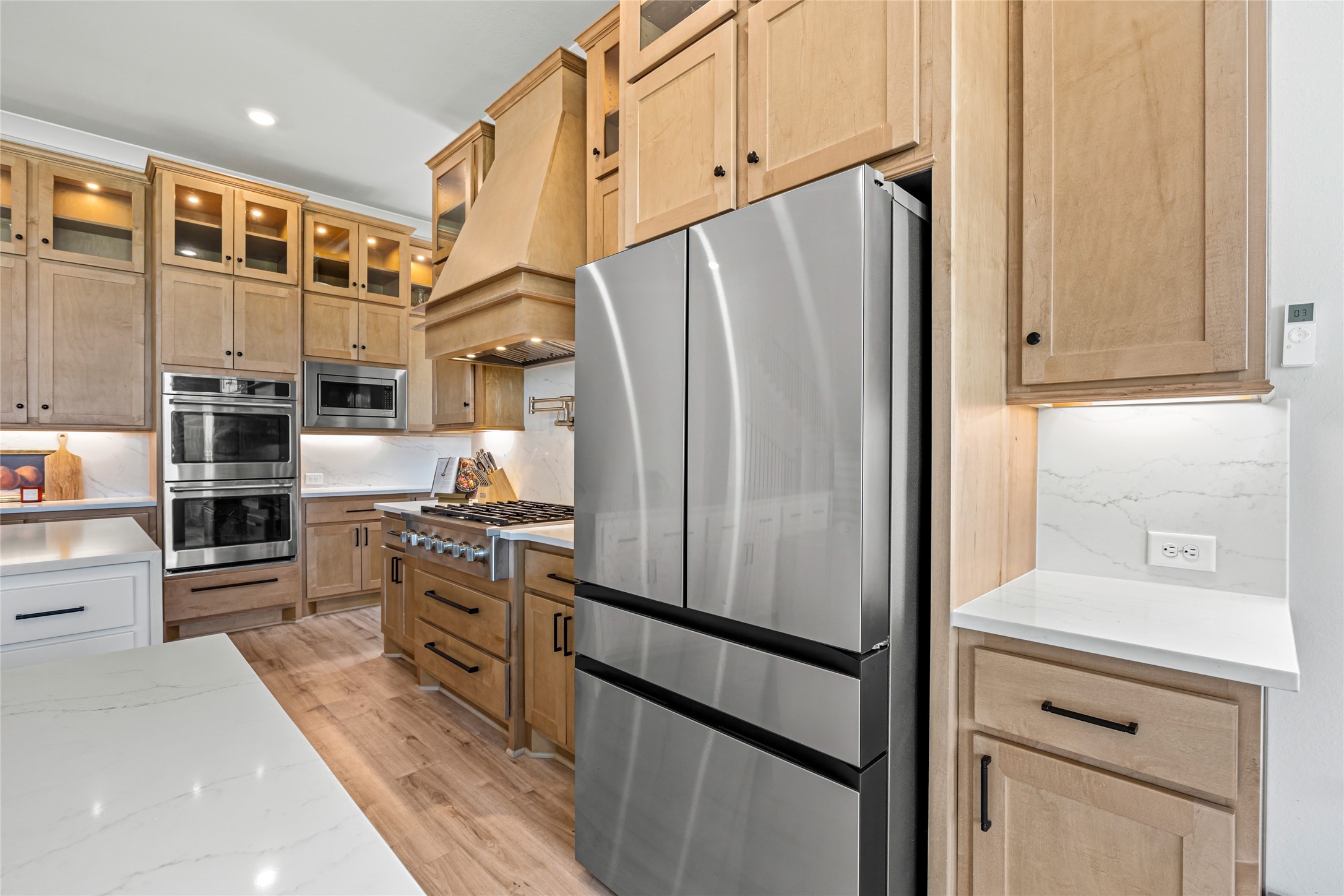 Elegant, high-end cabinets with soft under-cabinet lighting set a cozy yet luxurious mood in the kitchen