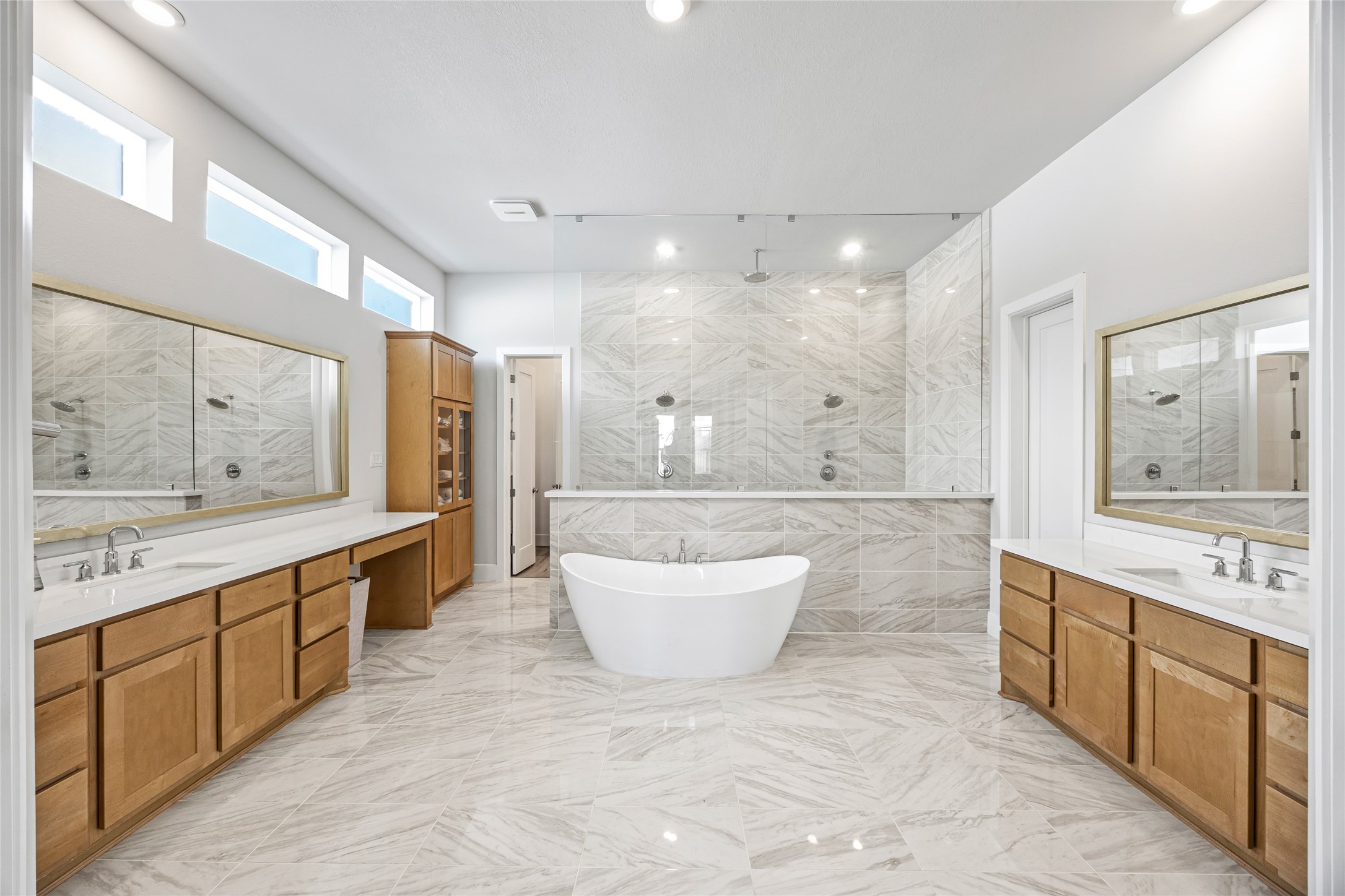 A spacious, elegant master bath with a double-wide shower and a stunning tub positioned at the perfect angle for relaxation