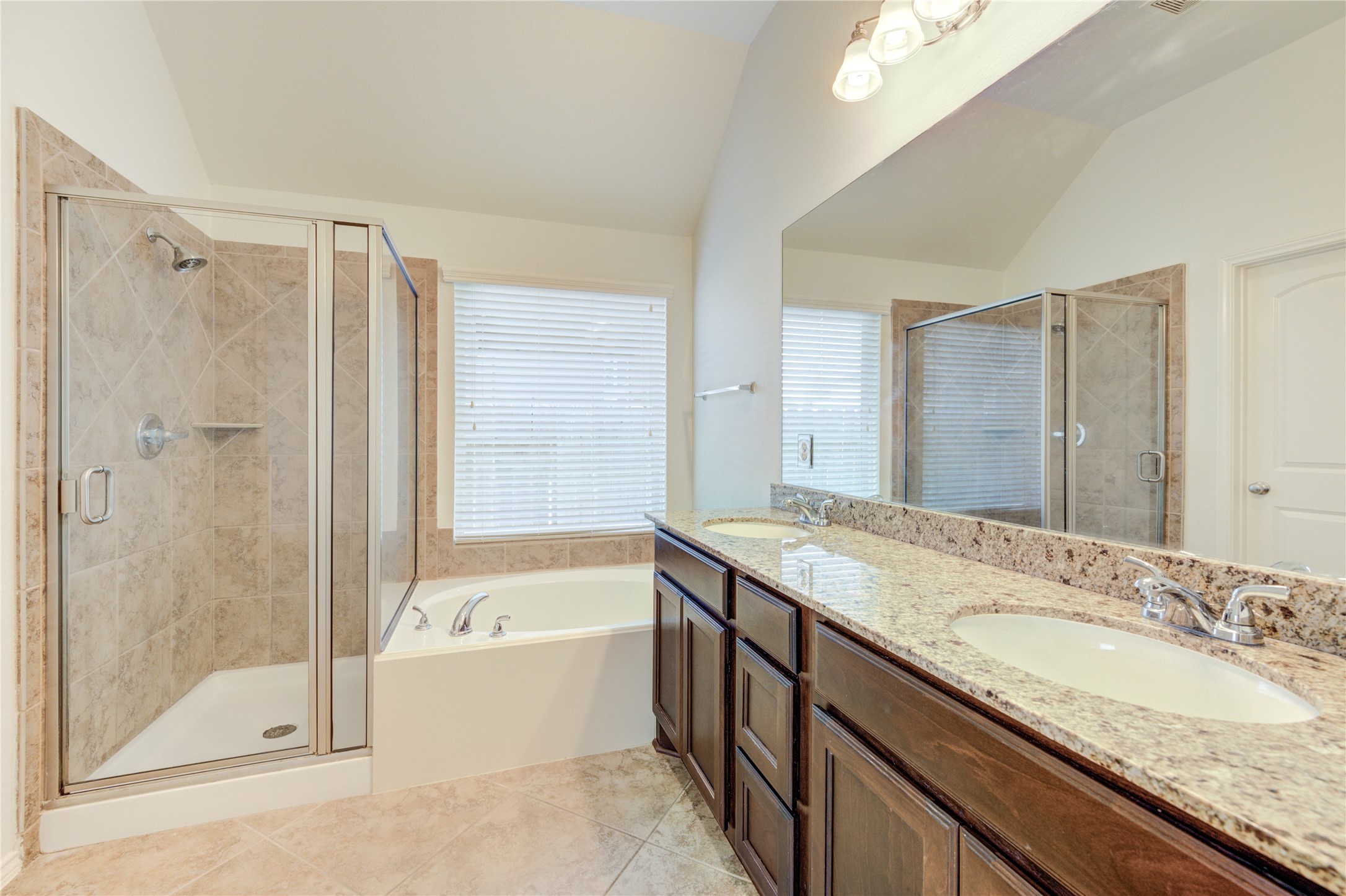 primary suite with walk in shower and garden tub