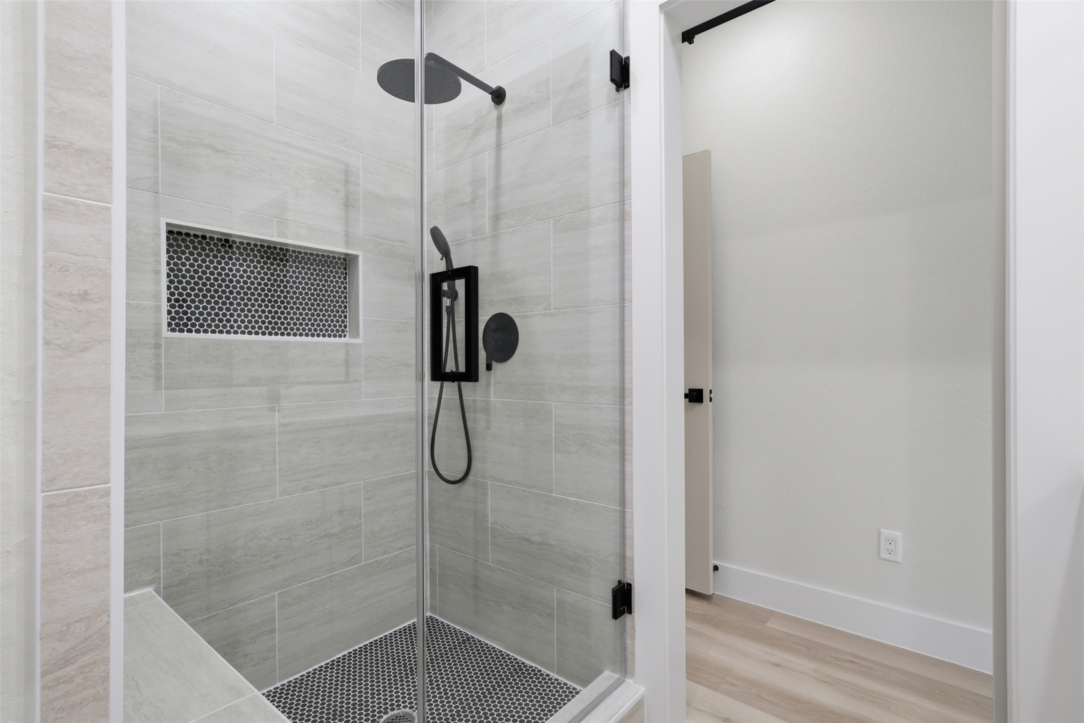 Sleek and modern shower with elegant tilework, glass doors, and a convenient built-in niche for storage.