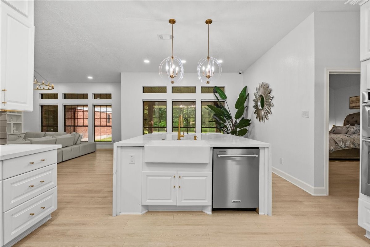 Oversized designer pendant lighting adds warmth and character above the island, creating a striking focal point that perfectly complements the home's elevated farmhouse style.