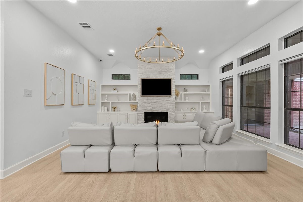 Soft natural tones, light wood-look flooring, and layered designer finishes come together to create a family room that feels timeless, comfortable, and effortlessly elegant.