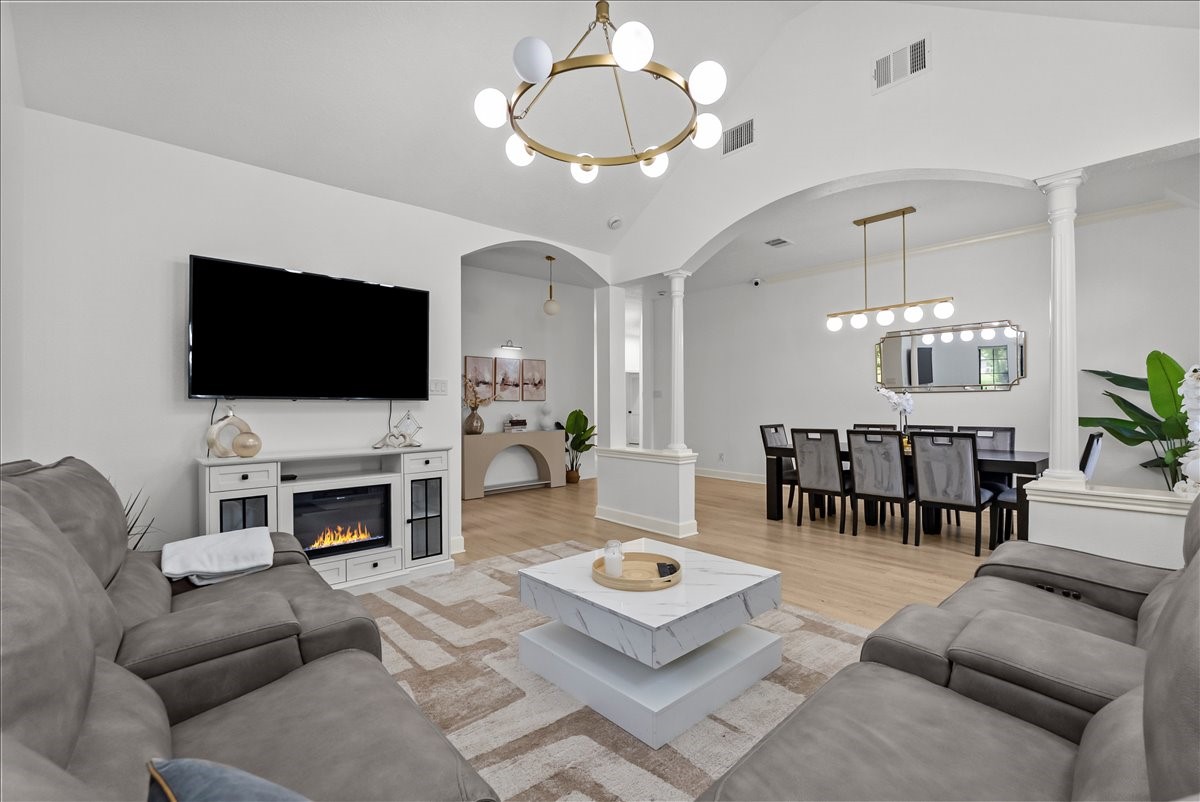 The inviting den is anchored by a striking chandelier with oversized Edison-style bulbs, adding warmth, character, and a touch of modern farmhouse elegance.