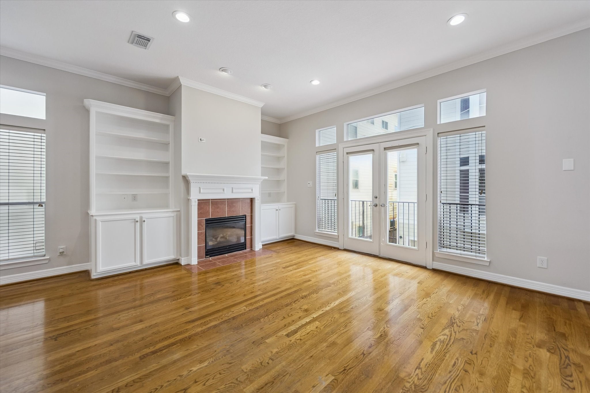 Living area anchored by a handsome fireplace and set of French doors that lead out to a balcony! Also note the elegant built in bookshelves and storage! Living area anchored by a handsome fireplace and set of French doors that lead out to a balcony! Also note the elegant built in bookshelves and storage!