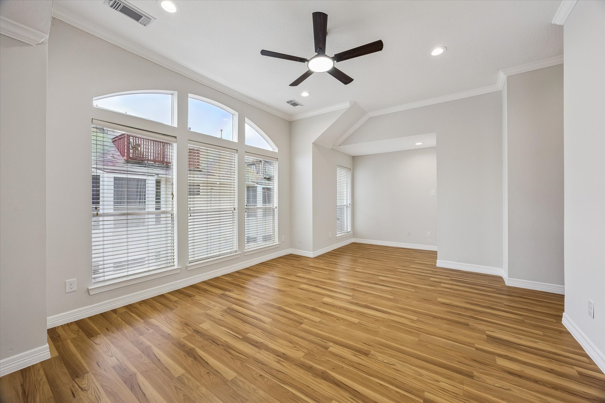 Another view of the primary! Recent installation of wood laminate flooring here! Little niche area at far end could be a lovely reading corner with your favorite armchair! Opposite is a door that leads to a staircase to the attic space and "possible" future roof deck!