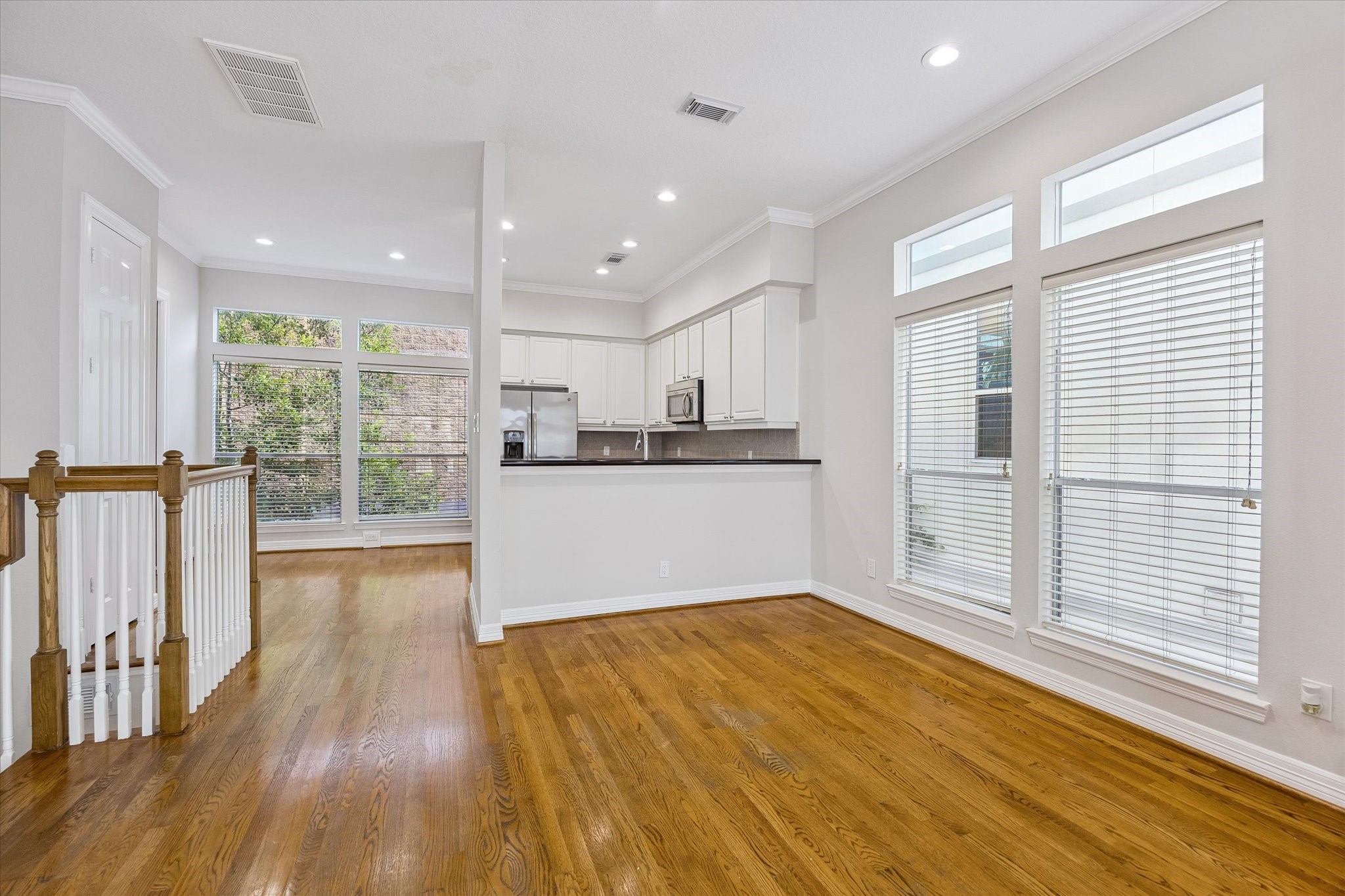 Dining area with large bank of windows. Notice the open flow and light between kitchen, breakfast area, dining, and living!
