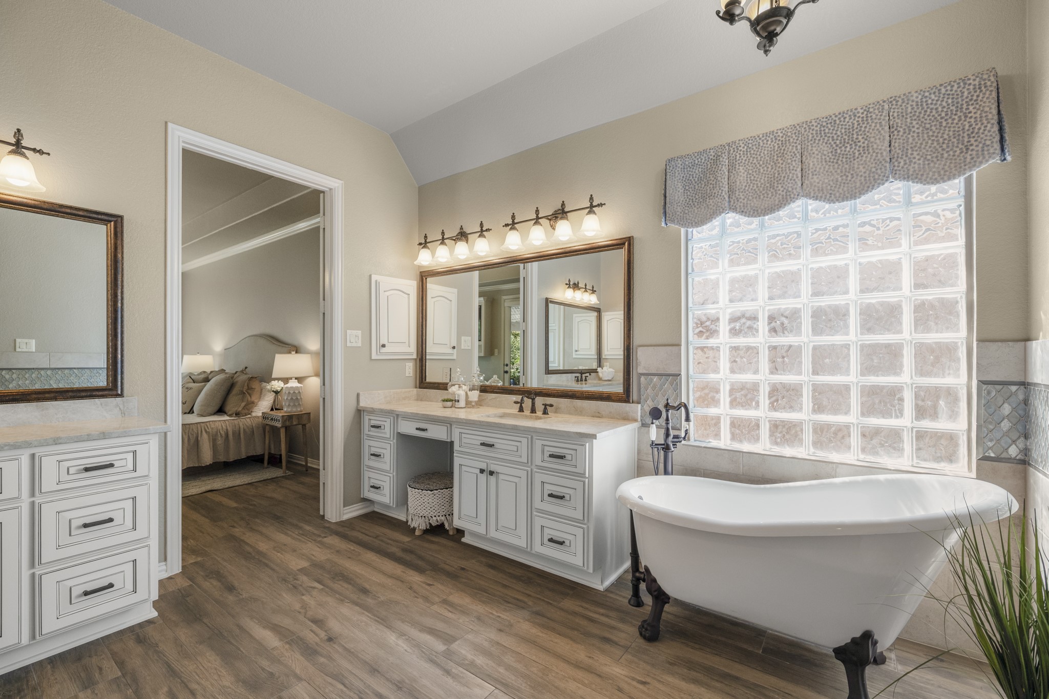Taking one final look at the remodeled primary bath, the custom finishes feel especially polished with Taj Mahal quartzite, framed mirrors, upgraded lighting, and oil-rubbed bronze fixtures carrying across the dual vanities. The freestanding clawfoot tub and glass-enclosed shower complete the retreat-like feel, keeping the primary suite focused on comfort, finish, and a slower start or end to the day.