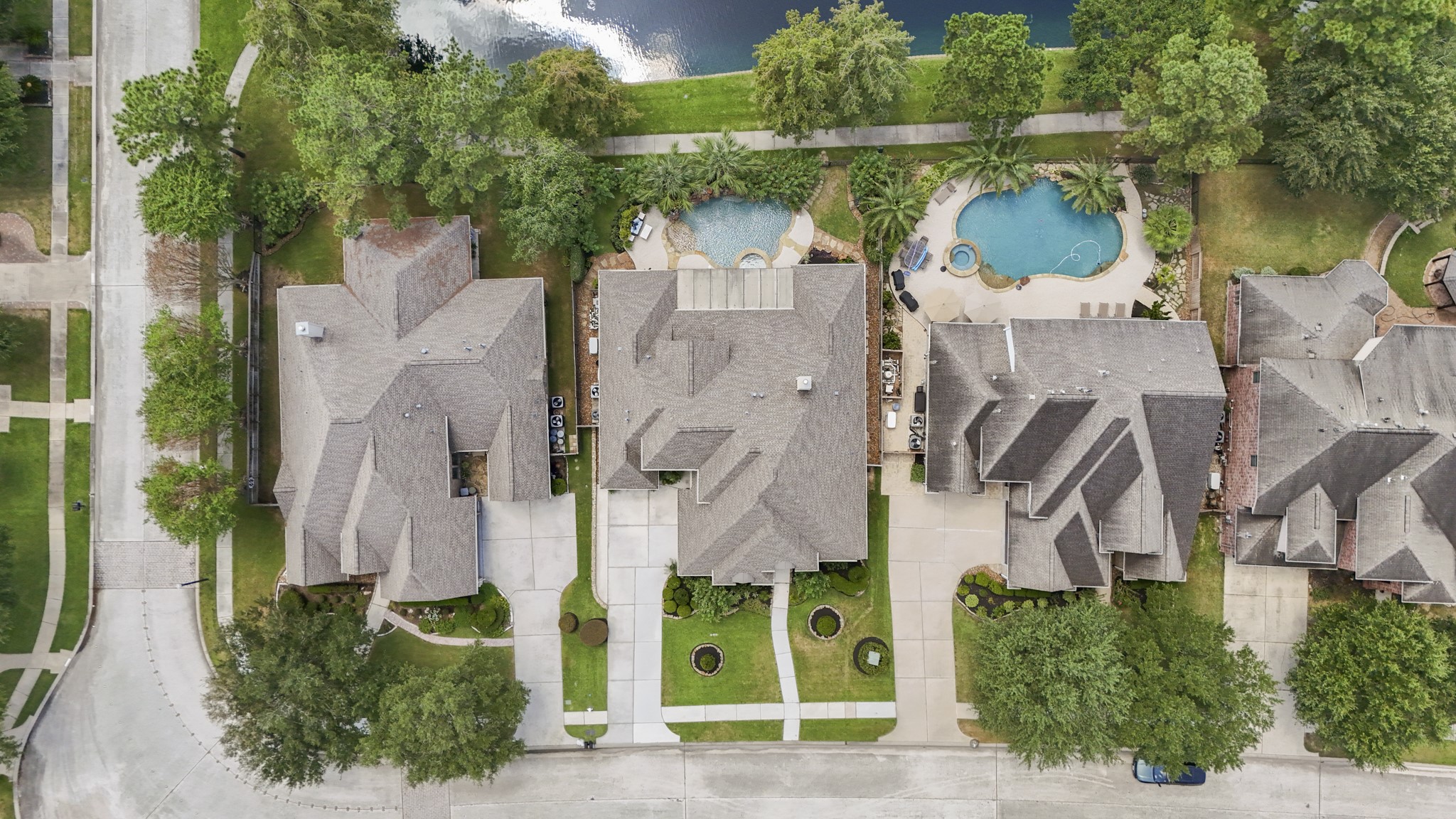 From above, the homes layout shows how closely the outdoor spaces are tied to the water-front setting, with the pool, raised spa, and covered patio tucked between the home and the water beyond. The front drive and garage space face the street, while the backyard opens toward the trails and greenery, giving buyers a clear look at how the home is positioned for both privacy and poolside living.
