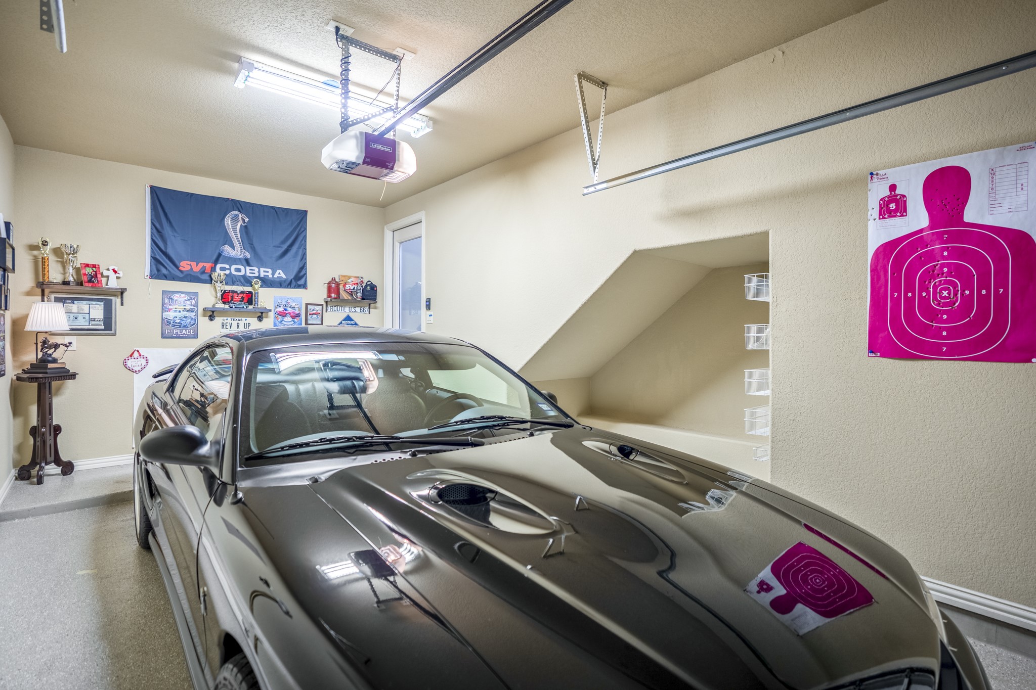 Inside the separate third garage bay, this view highlights the flexibility of the homes 3-car garage space along with the under-stairs storage built into the back wall. Epoxy flooring, overhead storage potential, and the tucked-away storage nook add a practical side to the layout while still keeping this garage bay distinct from the main 2-car garage.