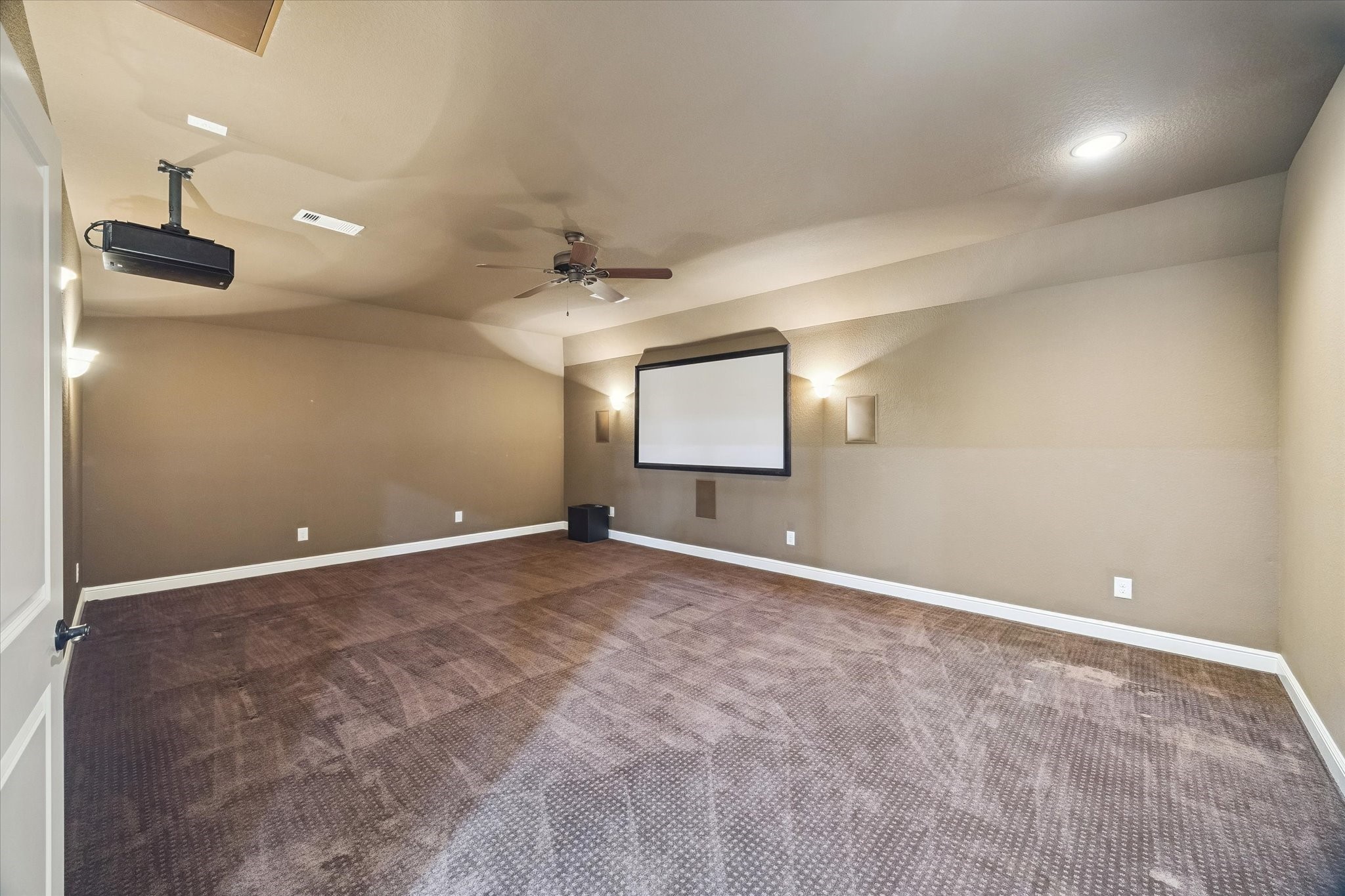 Enjoy a private theater experience from the comfort of home in this expansive media room, featuring a projection screen, projector, and abundant space for multiple seating arrangements. Whether hosting movie nights, watching the big game, or gaming with friends, this versatile space is designed for memorable entertainment.