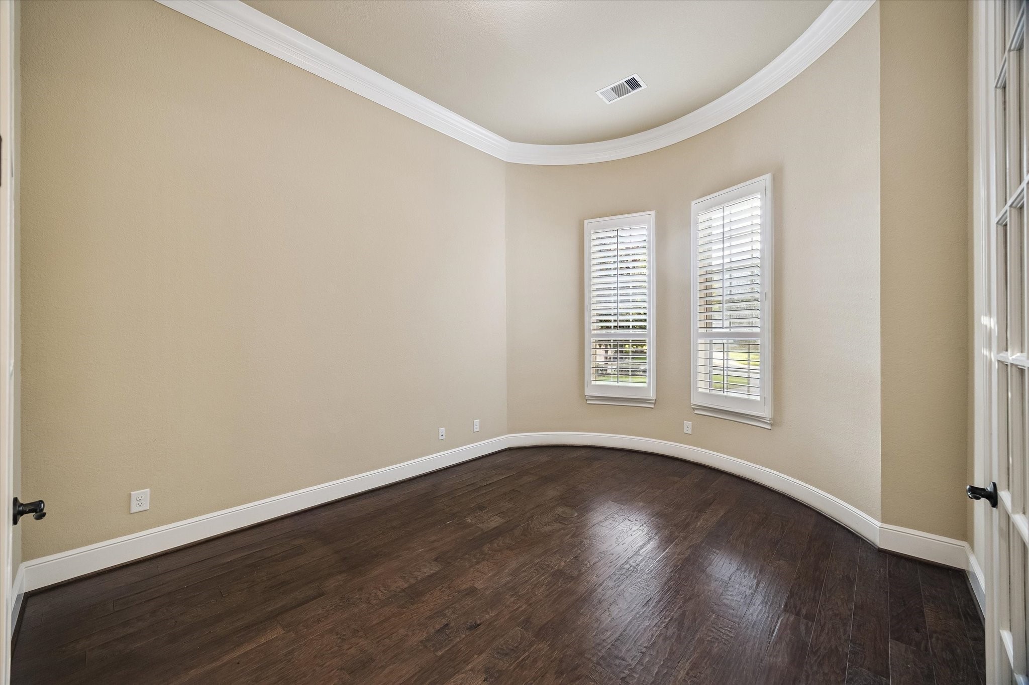 Conveniently positioned near the front of the home, this spacious study features elegant French doors, crown molding, rich hardwood flooring, and abundant natural light, creating an ideal setting for a home office or library. Conveniently positioned near the front of the home, this spacious study features elegant French doors, crown molding, rich hardwood flooring, and abundant natural light, creating an ideal setting for a home office or library.