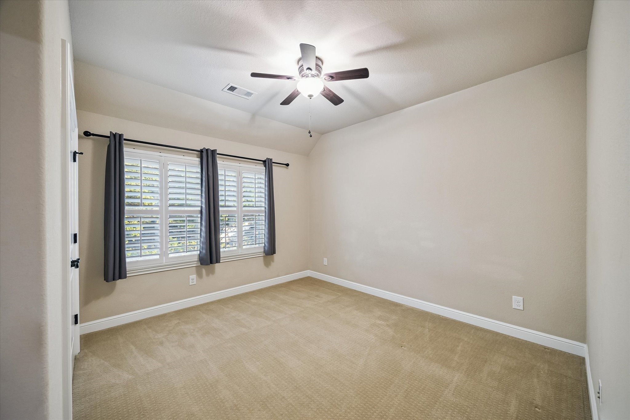 This inviting secondary bedroom features plantation shutters, soft natural light, and a spacious layout. Thoughtfully designed to provide comfort and flexibility for family, guests, or a personalized workspace.