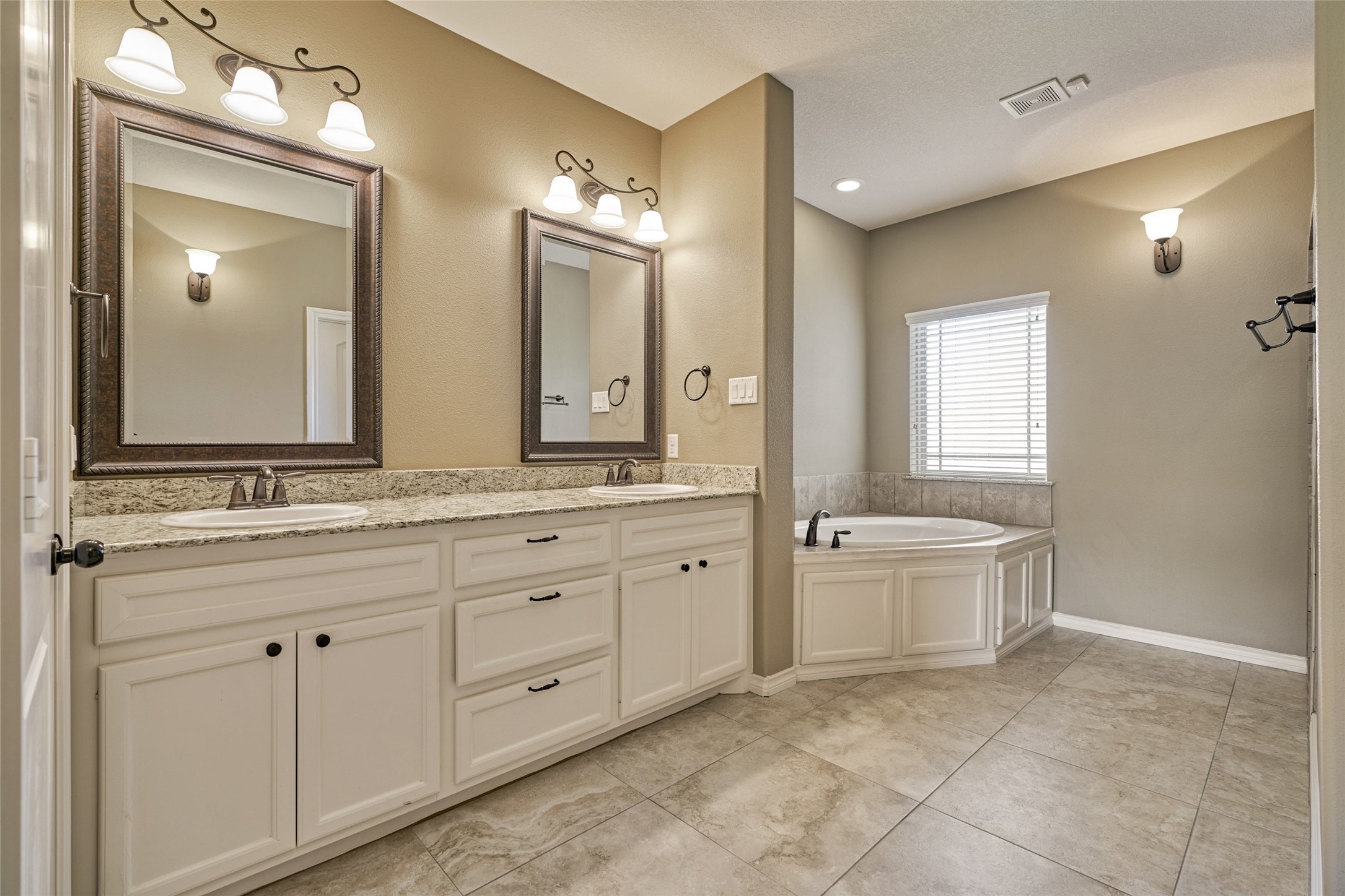 Spa-like primary ensuite with dual vanities, soaker tub and walk-in shower.