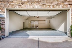 Two car garage with shelves and small storage area on left