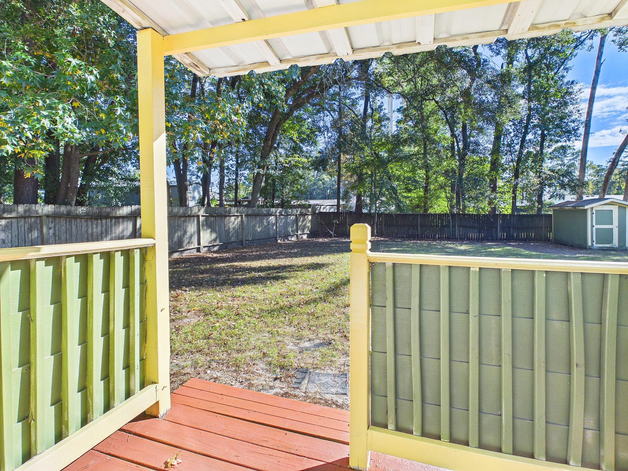 Charming porch overlooking a spacious, tree-lined backyard, perfect for outdoor relaxation and privacy.