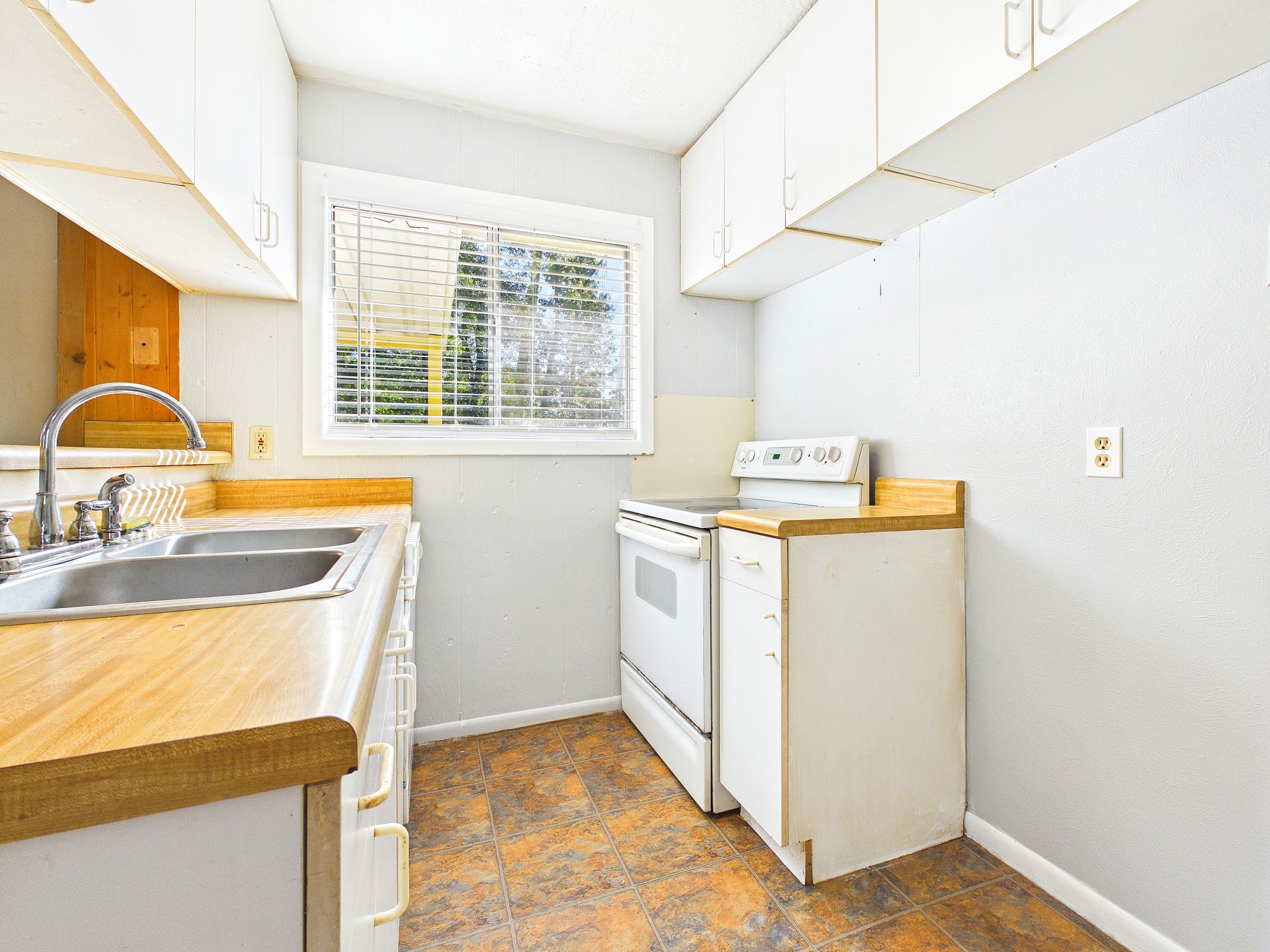 Cozy kitchen with ample natural light, white cabinets, sleek countertops, and a functional layout.